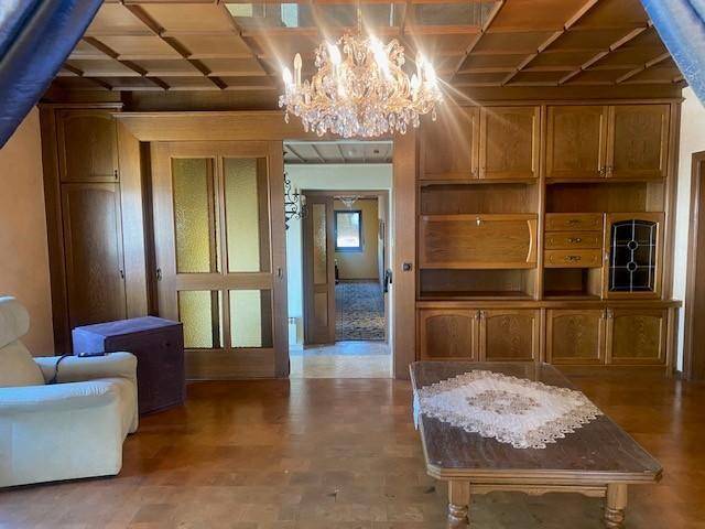 Gemütliches Wohnzimmer mit Holzkassettendecke, Parkettboden und traditionellen Holzmöbeln.