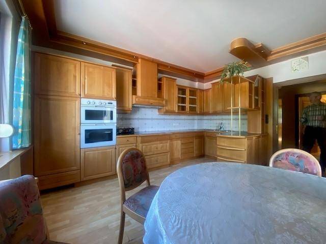 Geräumige Wohnküche mit Holzschränken, integrierten Geräten und Essbereich.