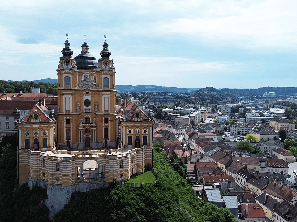 Beeindruckende Luftaufnahme eines historischen Klosters und der umliegenden Stadt mit vielen Gebäuden.