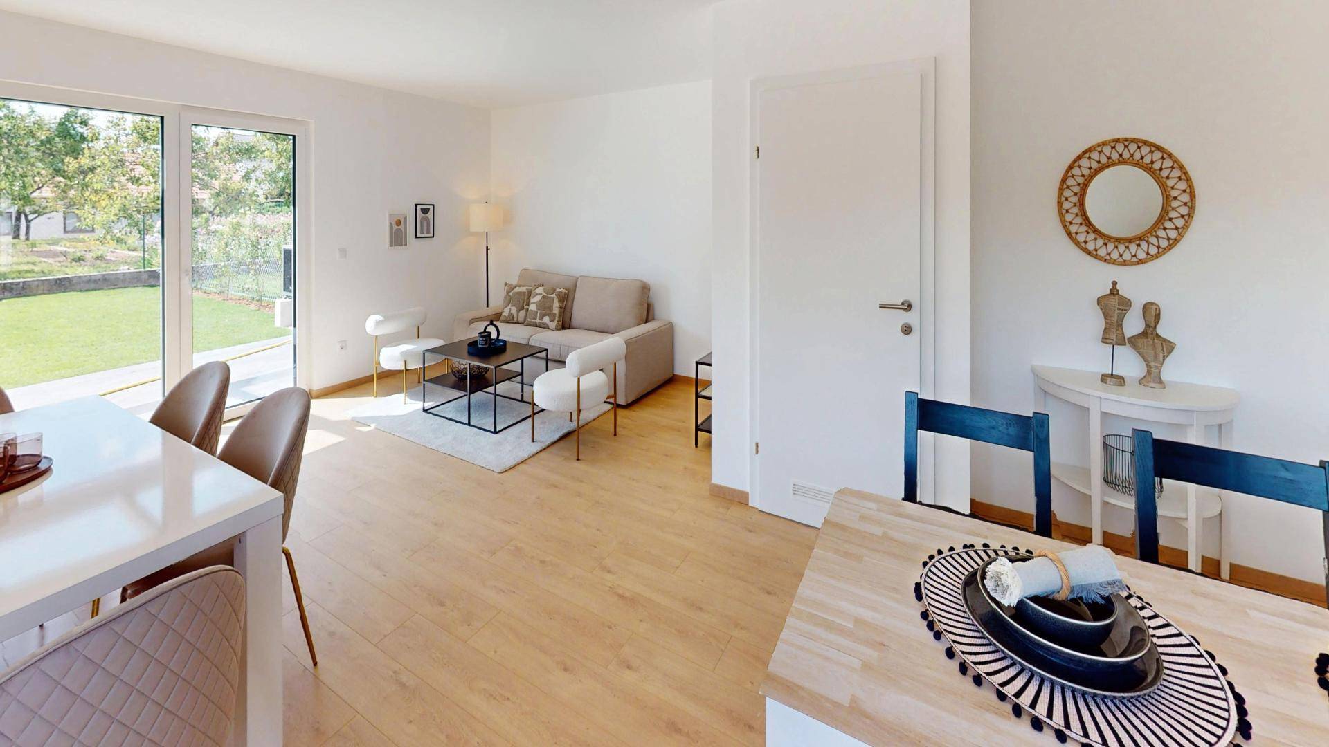Heller Wohnbereich mit Sofa, Esstisch und großen Fenstern, die den Blick in den Garten freigeben.