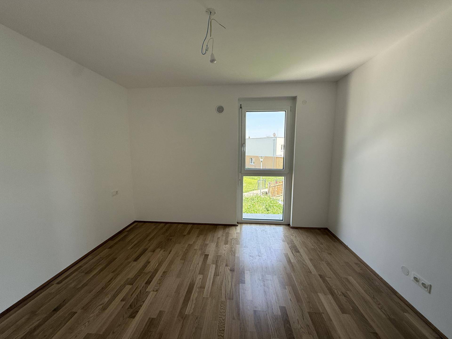 Weiteres helles Zimmer mit Parkettboden und Fenster, vielseitig nutzbar für individuelle Bedürfnisse.