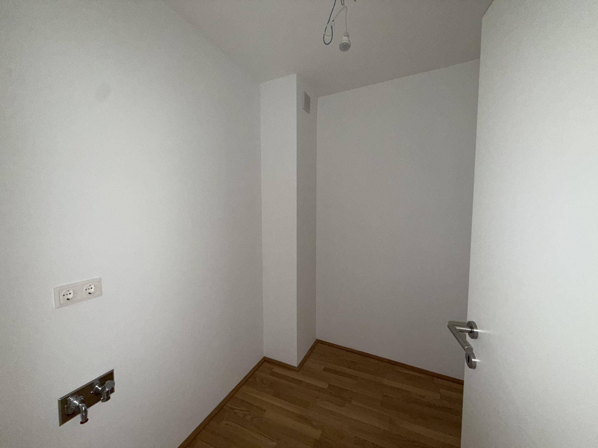 Praktischer Hauswirtschaftsraum mit Anschlüssen für Waschmaschine und Trockner, ideal für den Alltag.