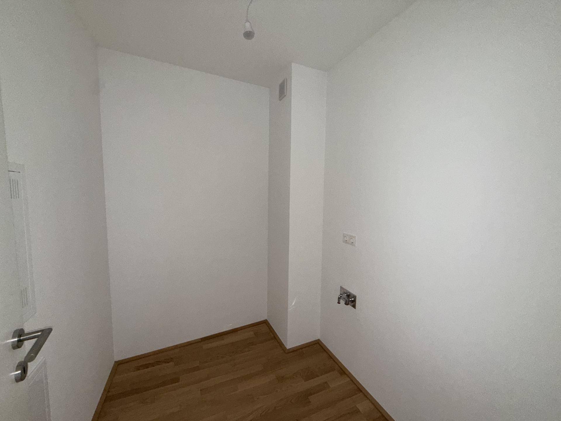 Kleiner Raum mit Parkettboden und Anschlüssen, ideal als Abstell- oder Hauswirtschaftsraum.
