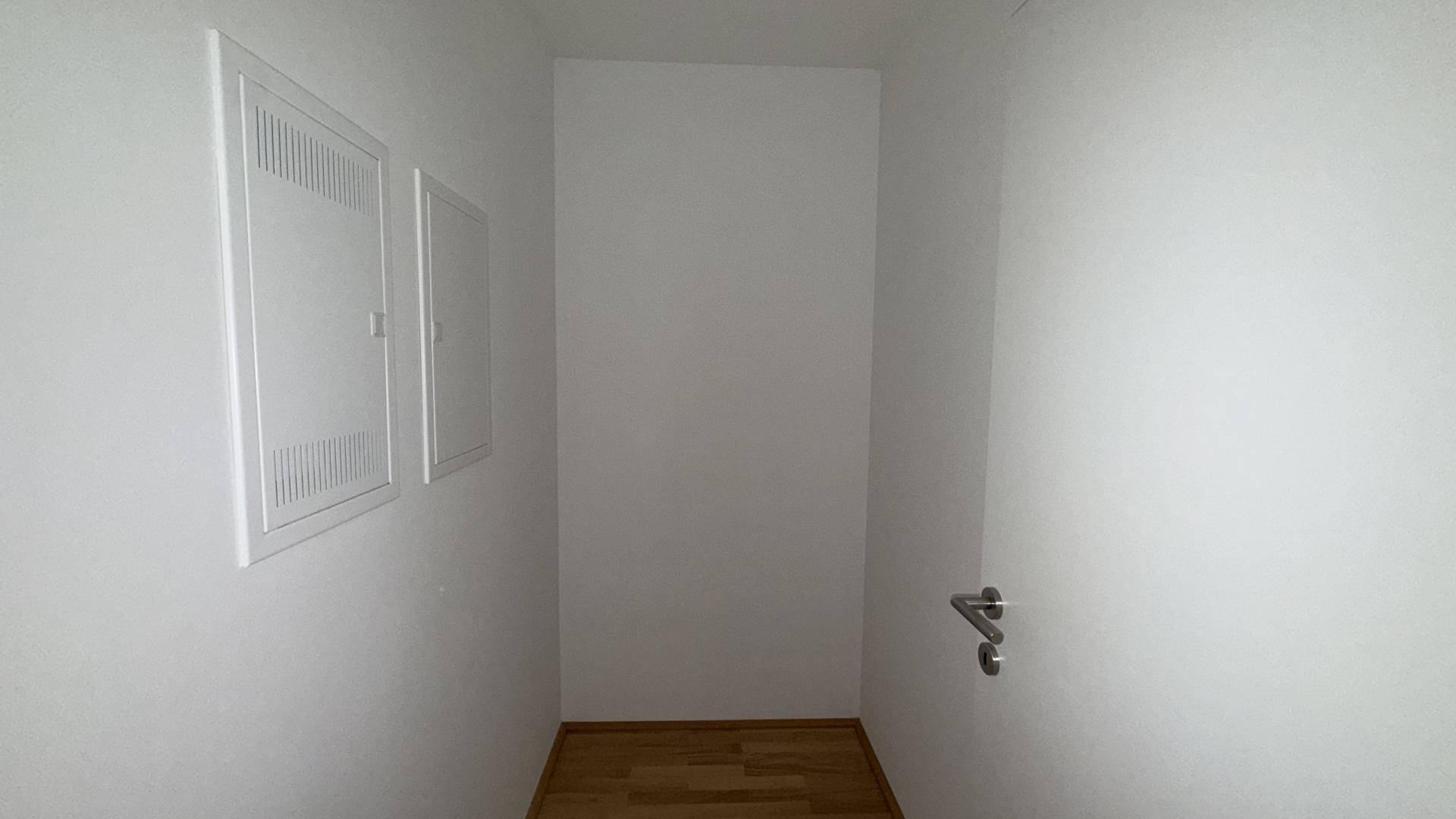 Kleiner Abstellraum mit Holzboden und weißen Wänden, ideal für Lagerzwecke oder Haustechnik.