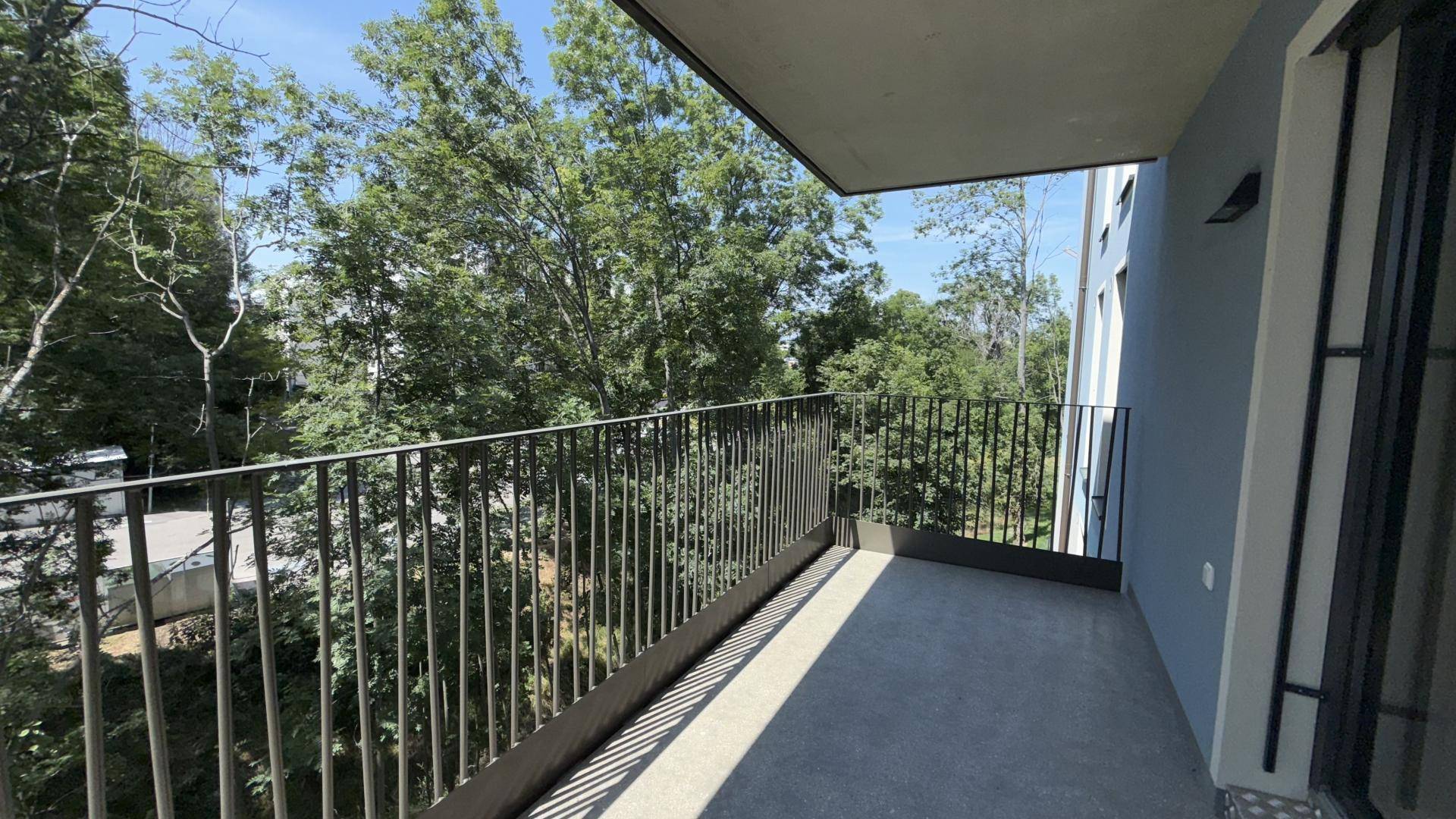 Geräumiger Balkon mit Metallgeländer und Blick ins Grüne, ideal zum Entspannen im Freien.