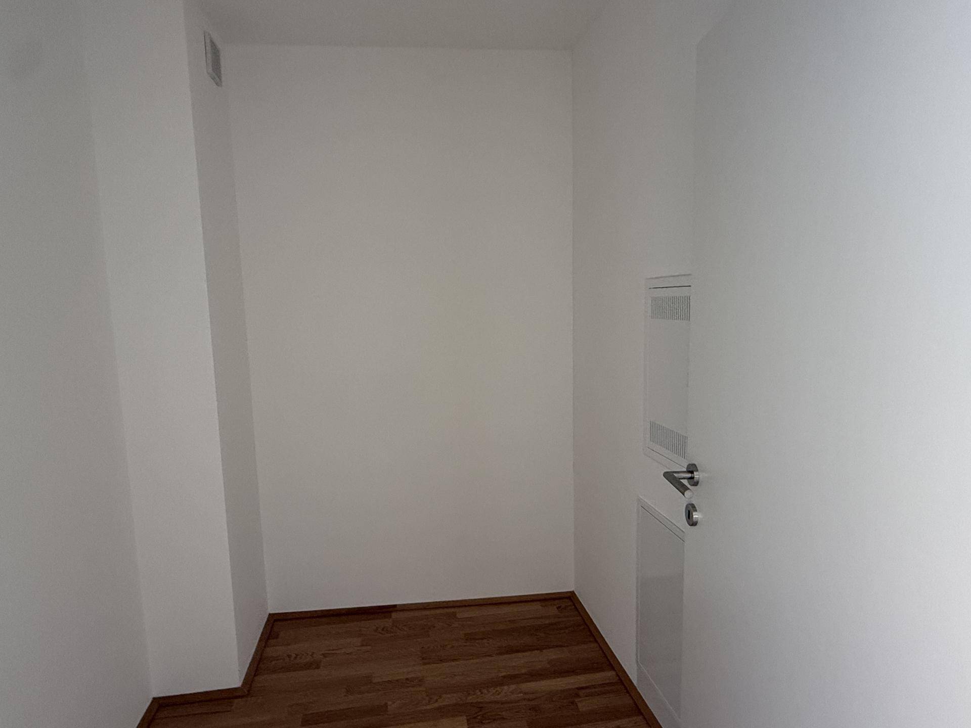 Kleiner Abstellraum mit Holzboden und weißen Wänden, ideal für zusätzlichen Stauraum.