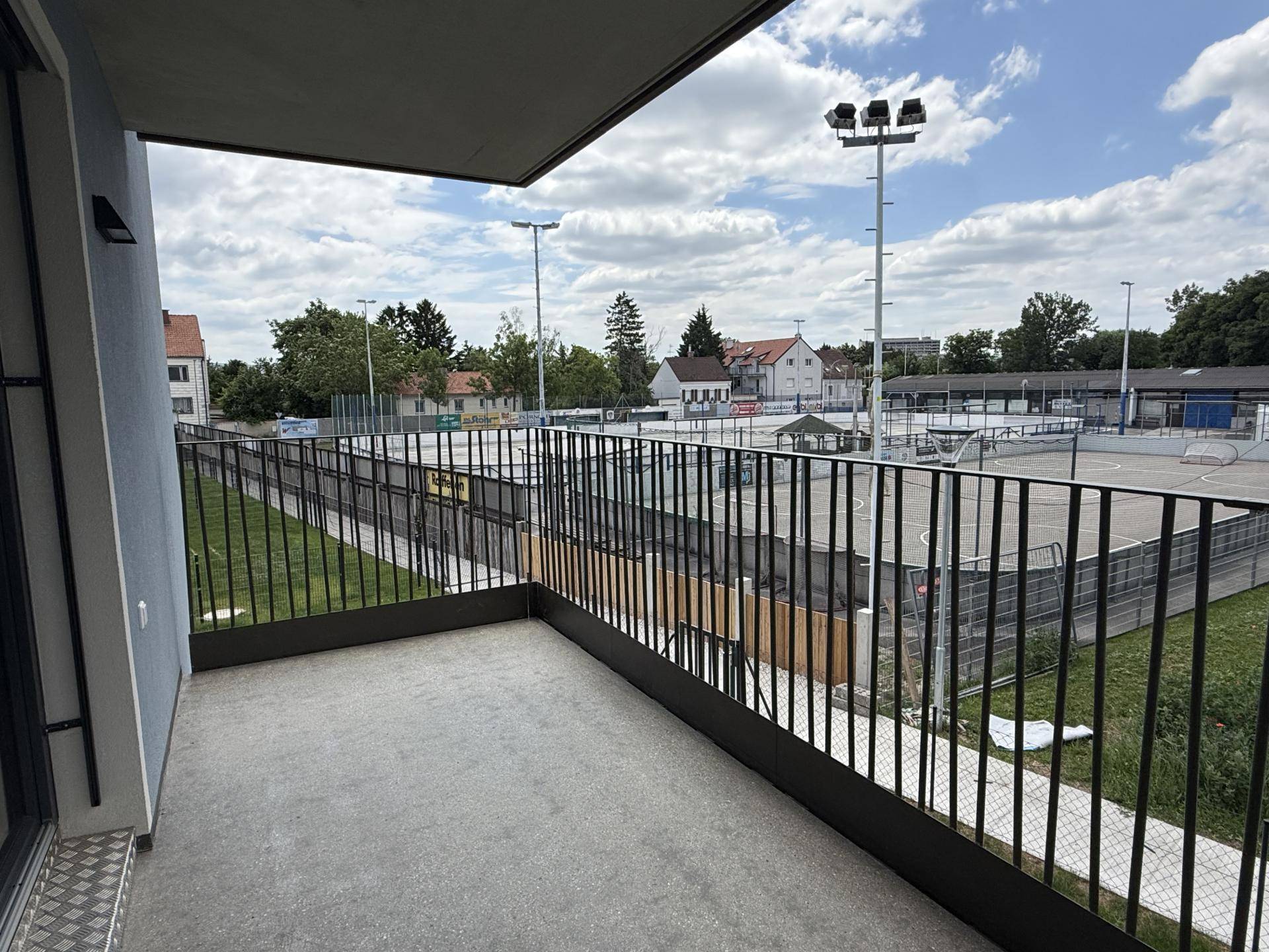 Balkon mit Blick auf einen Sportplatz, ideal für Entspannung im Freien.