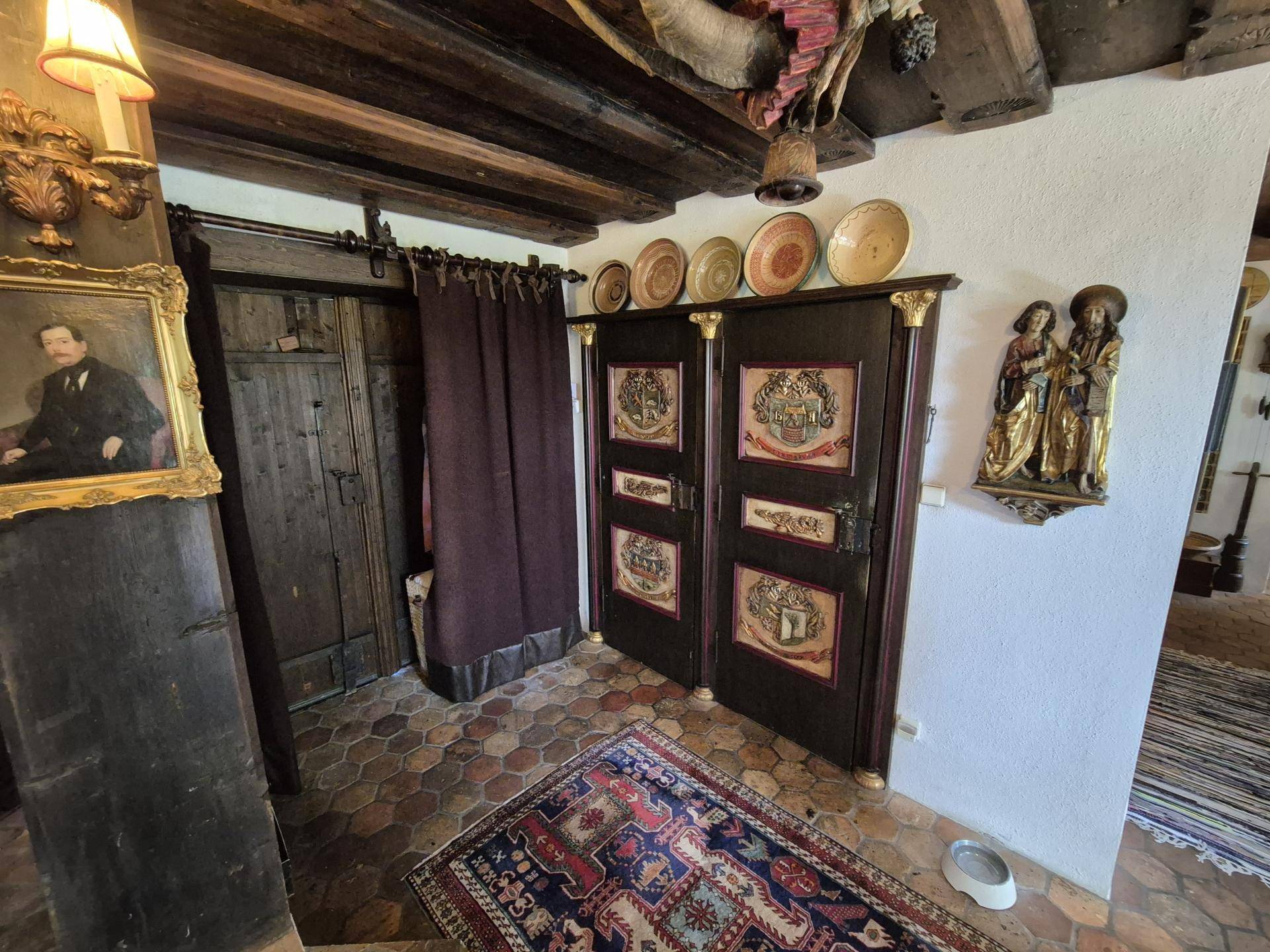 Eingangsbereich mit Terrakotta-Bodenfliesen, verzierten Holztüren und traditioneller Dekoration.