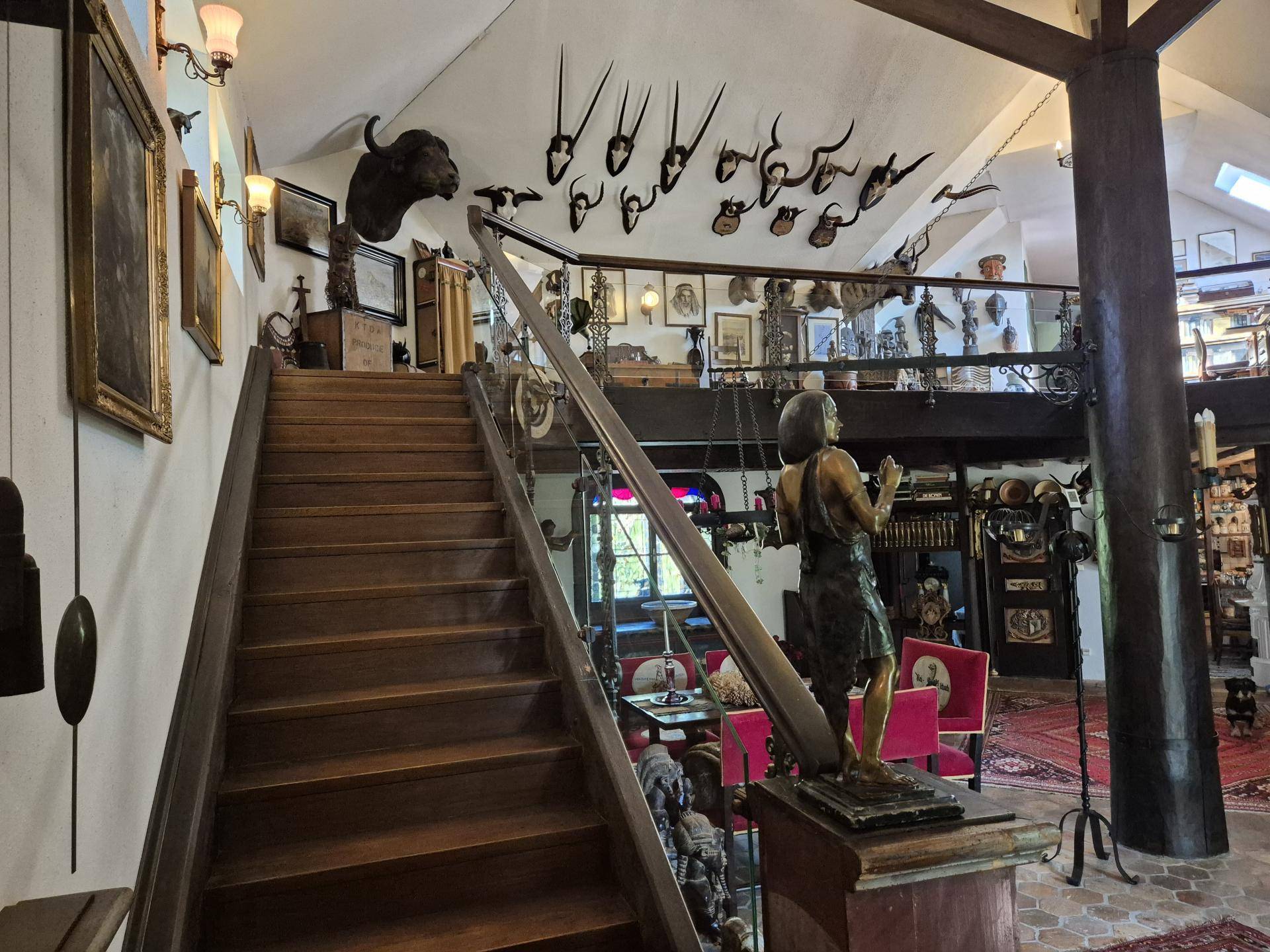 Elegante Holztreppe mit Geländer, die zu einem oberen Bereich mit weiteren Dekorationen führt.