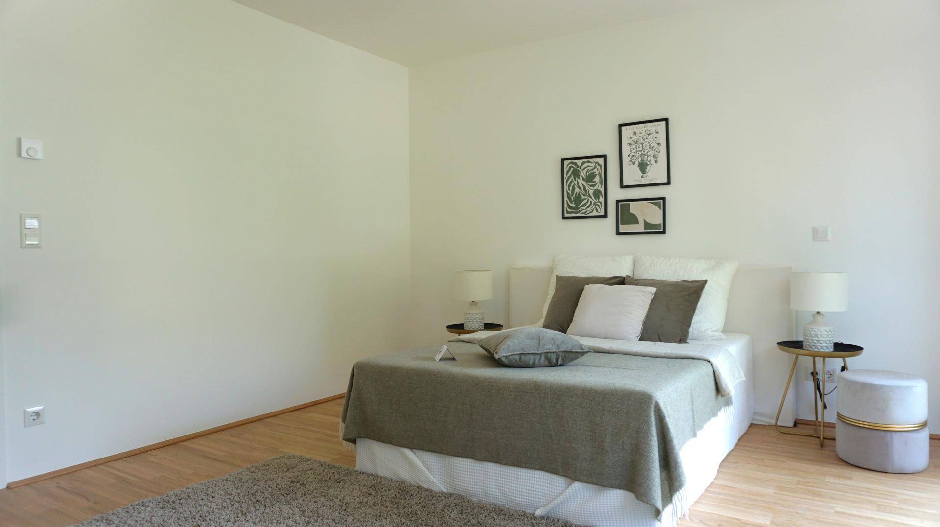 Helles Schlafzimmer mit Doppelbett, Nachttischen und moderner Wanddekoration.
