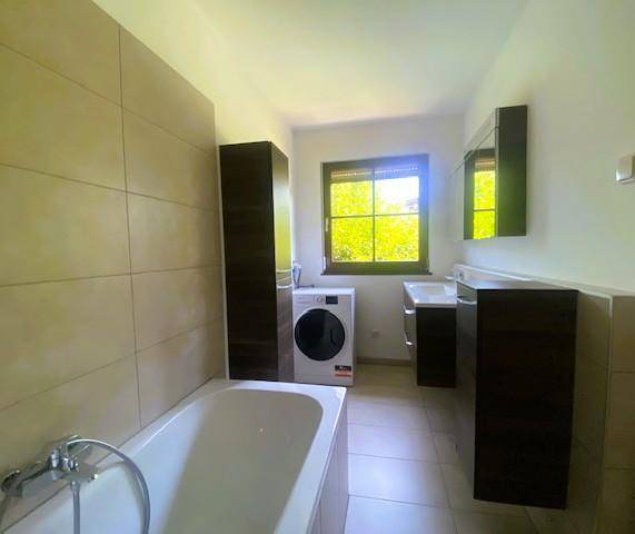 Badezimmer mit Wanne und Waschmaschine