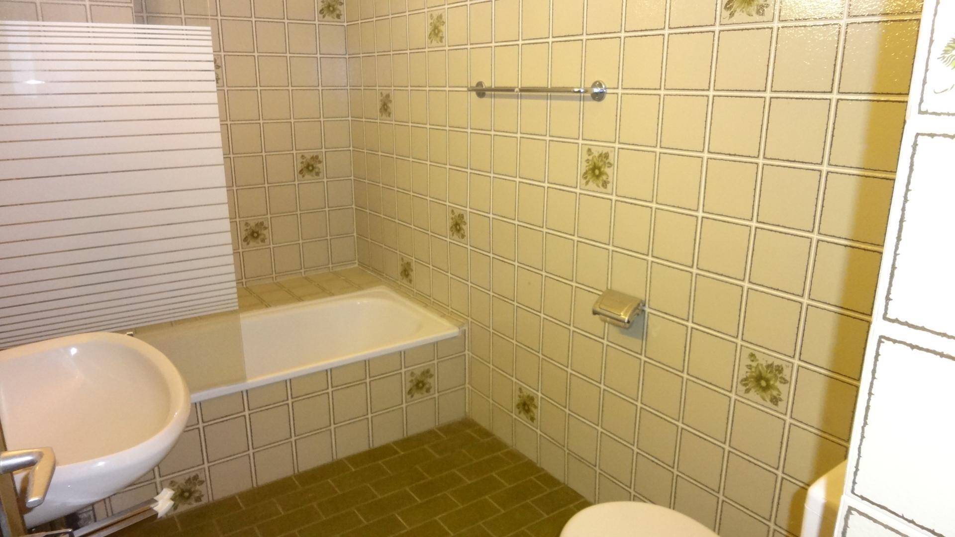 Badezimmer mit Badewanne und WC Haus 1
