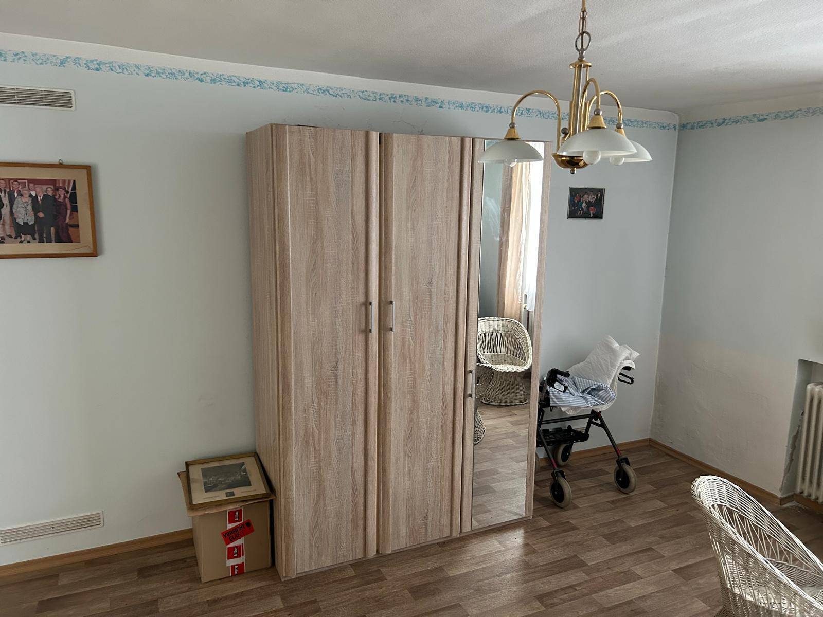 Geräumiger Raum mit großem Spiegelschrank und Laminatboden.