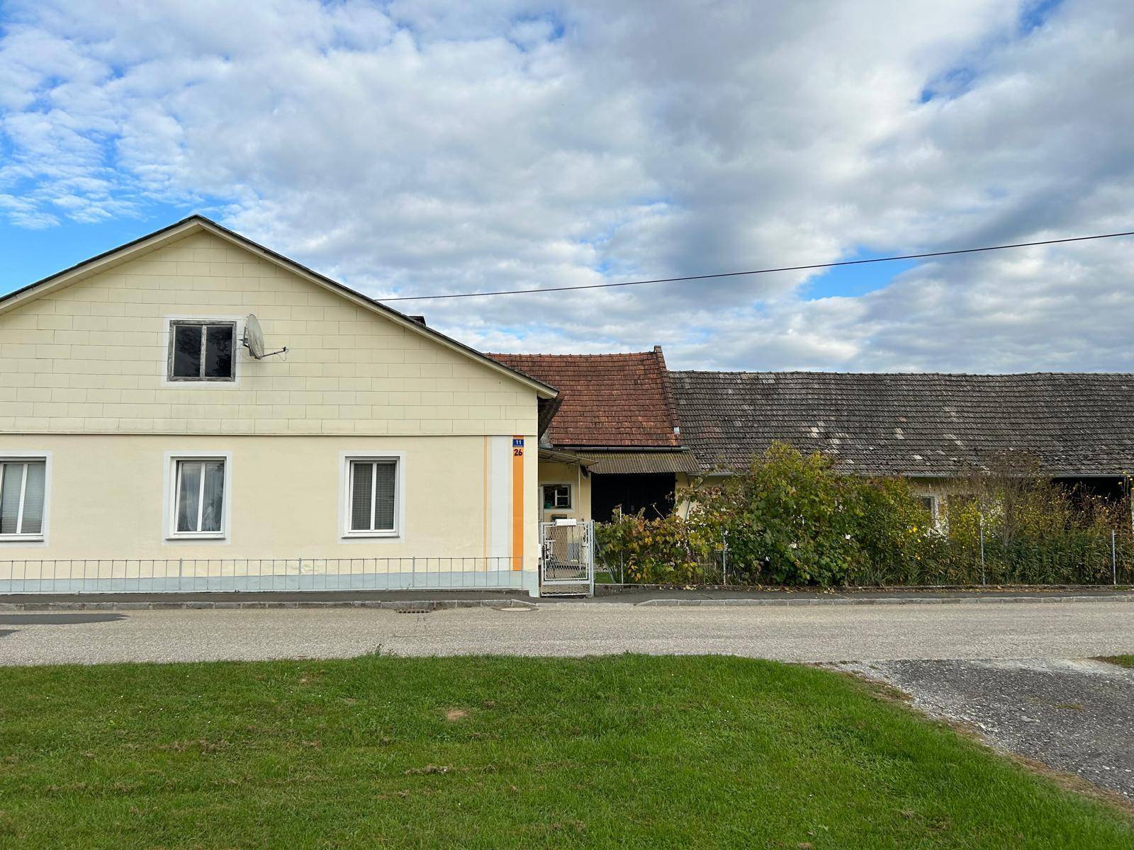 Ansicht des Anwesens von der Straße mit Wohnhaus und angrenzendem Wirtschaftsgebäude.