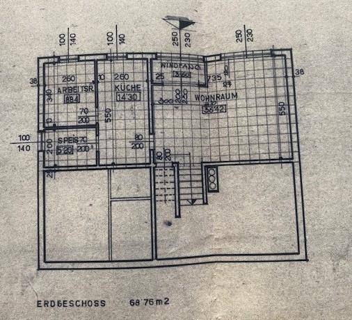 Grundriss des Erdgeschosses mit Wohnraum, Küche und Arbeitszimmer.