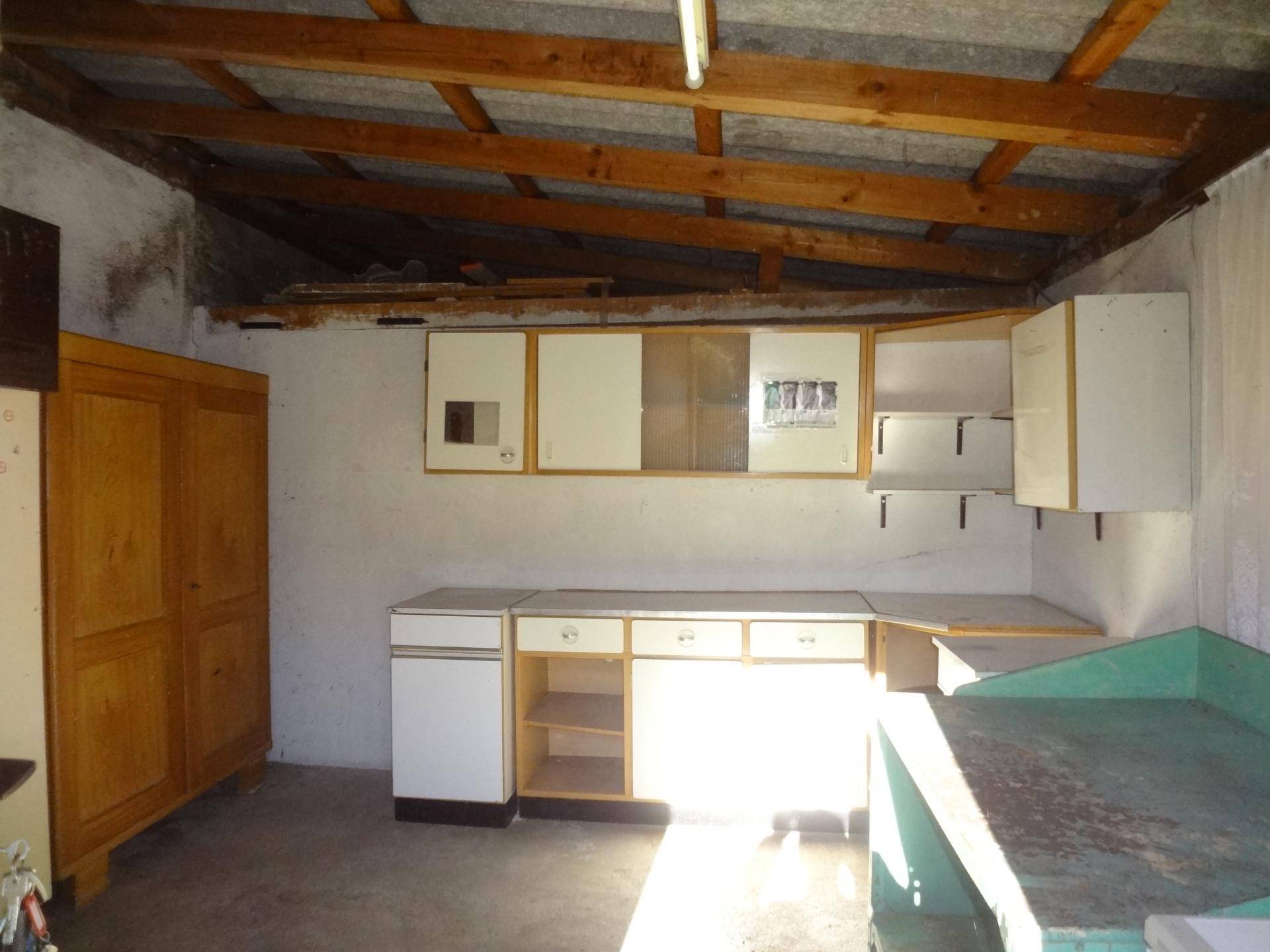 Werkstatt oder Abstellraum mit einfacher Einrichtung und Holzdecke.