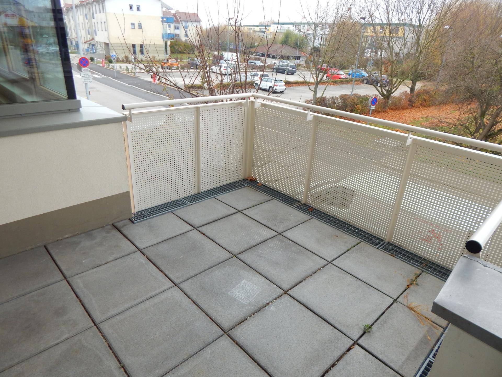 Außenbereich mit Fliesenboden und Gittergeländer, bietet Platz für Entspannung im Freien.