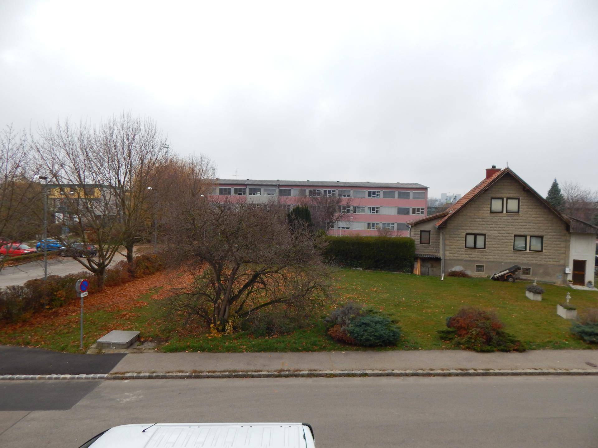 Weitläufiger Blick auf die Wohngegend mit Bäumen und umliegenden Gebäuden.