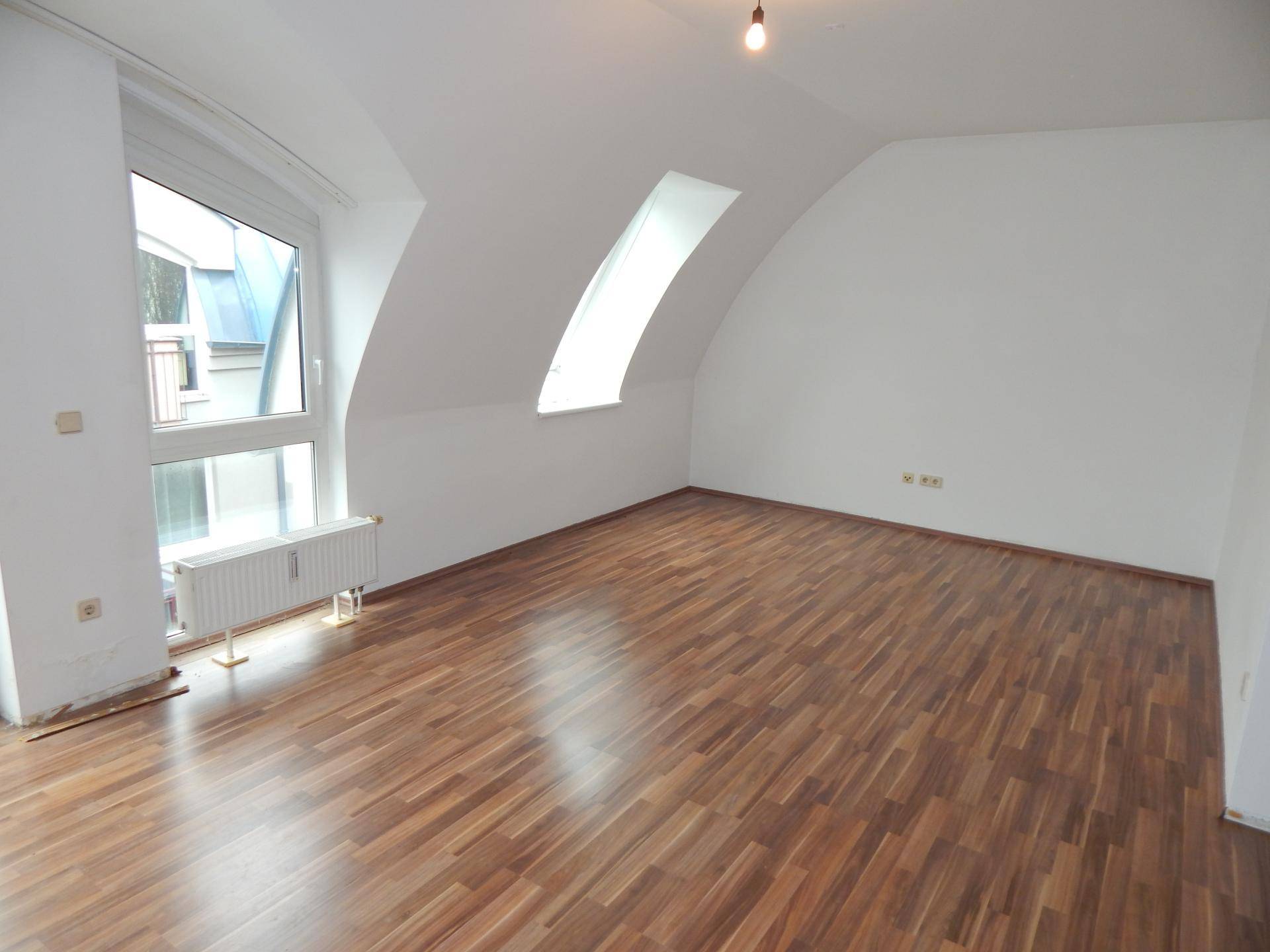 Geräumiges Schlafzimmer im Dachgeschoss mit Laminatboden, Dachschrägen und Dachfenstern.