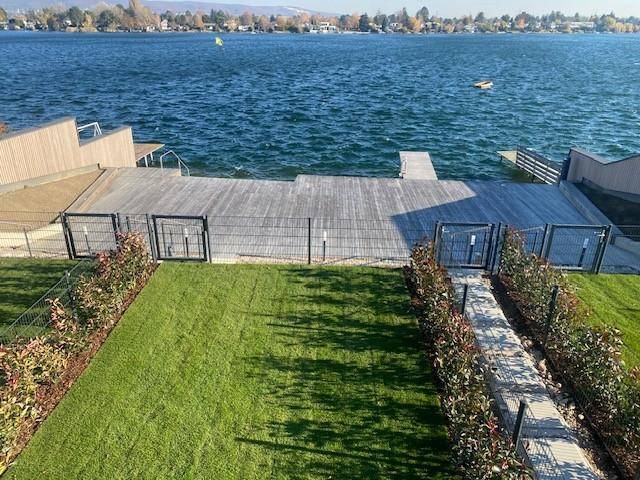 Gepflegter Rasenbereich mit direktem Zugang zu einer großen Holzterrasse am Seeufer.
