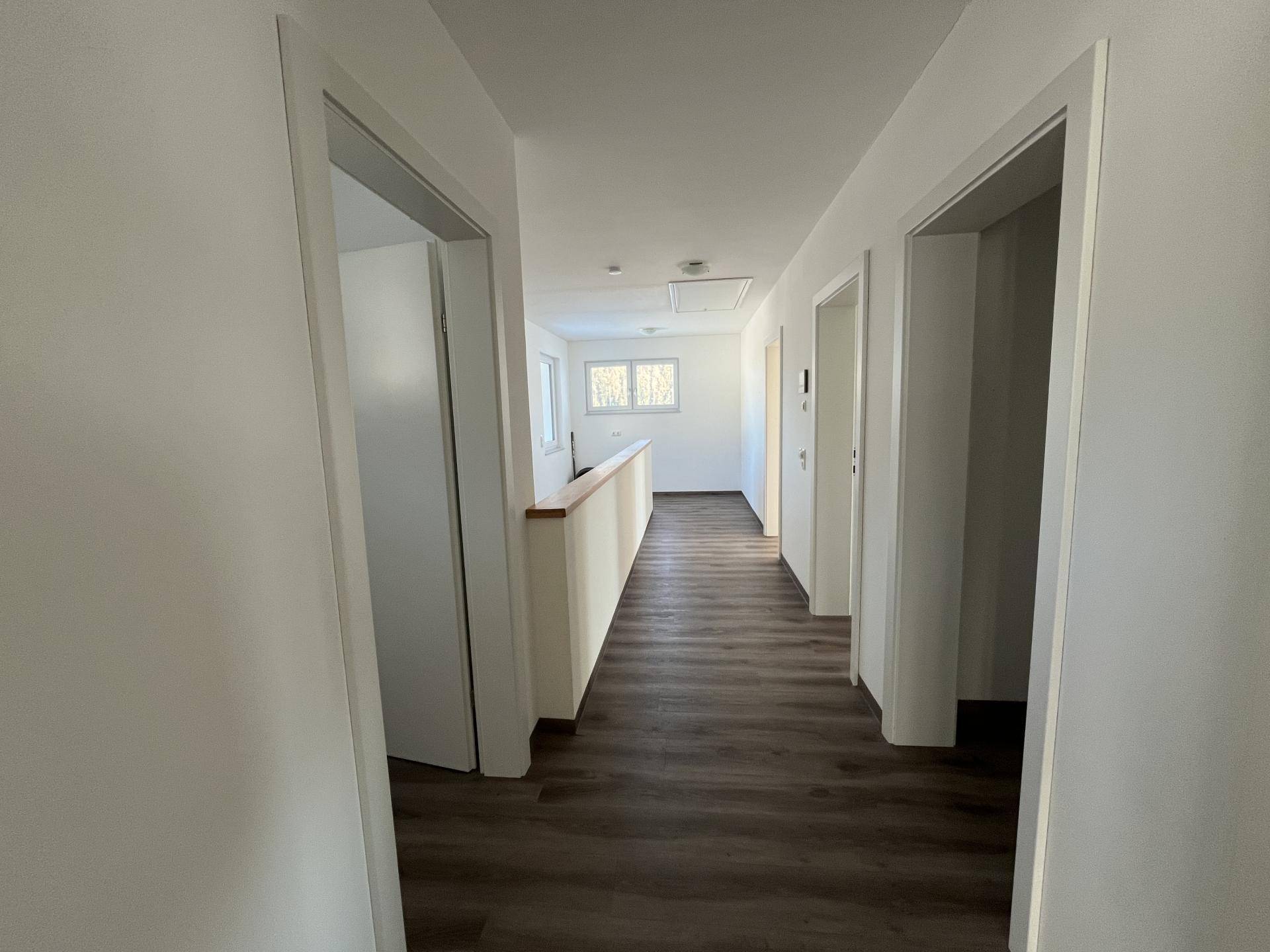 Heller Flur mit Laminatboden und Zugang zu mehreren Zimmern im Obergeschoss.