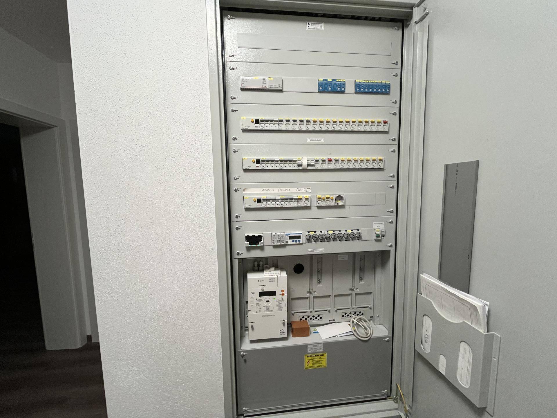 Elektrischer Verteilerkasten mit zahlreichen Sicherungen und Verkabelungen.
