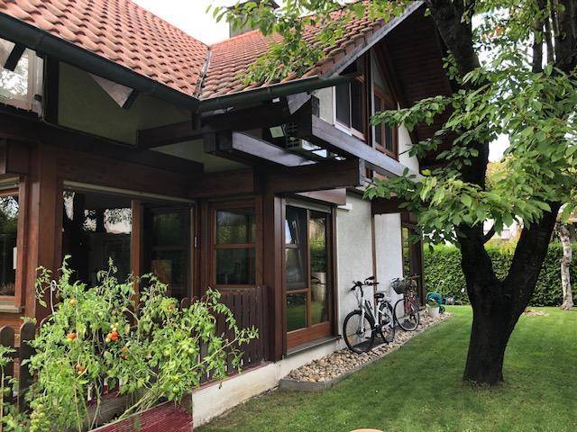 Seitenansicht des Hauses mit begrüntem Gartenbereich und Kiesstreifen.