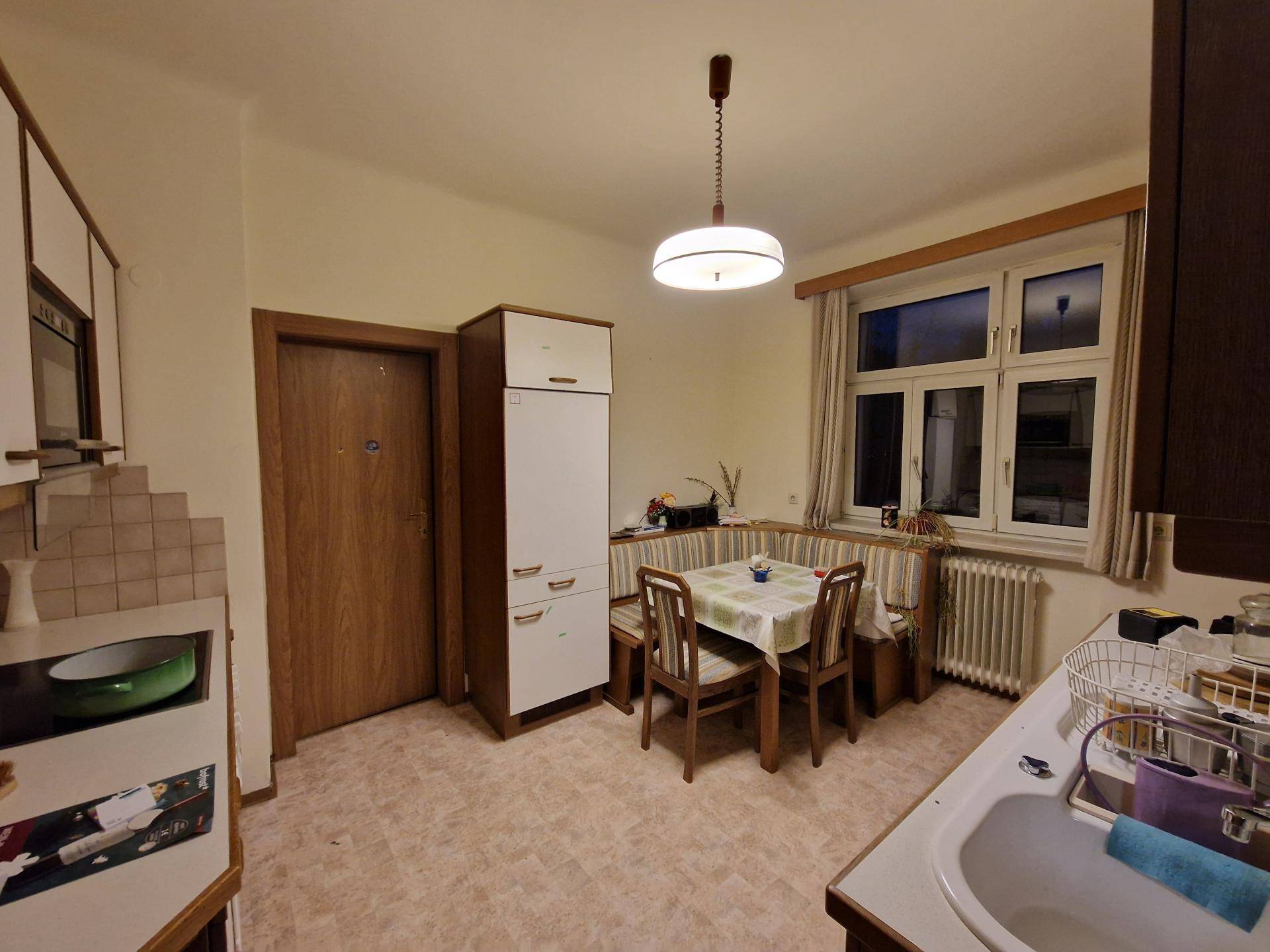 Funktionale Küche mit Essbereich, Einbauschränken und Fensterblick in den Garten.