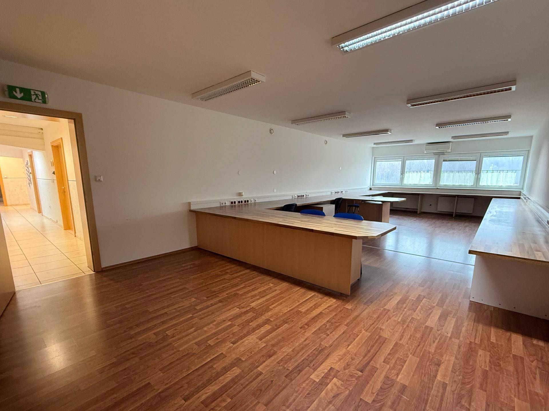 Großes, helles Büro mit mehreren Arbeitsplätzen und Blick auf den Flur, bietet viel Raum.