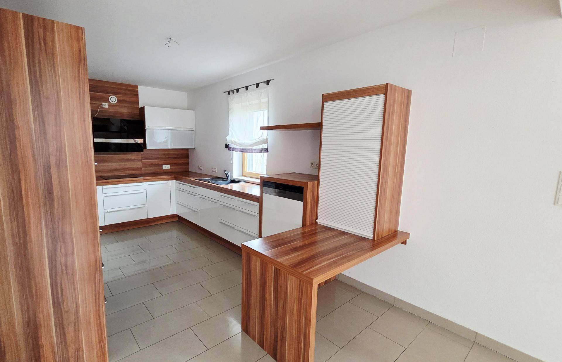 Moderne Einbauküche mit Holz- und weißen Fronten, integrierten Geräten und Fenster.