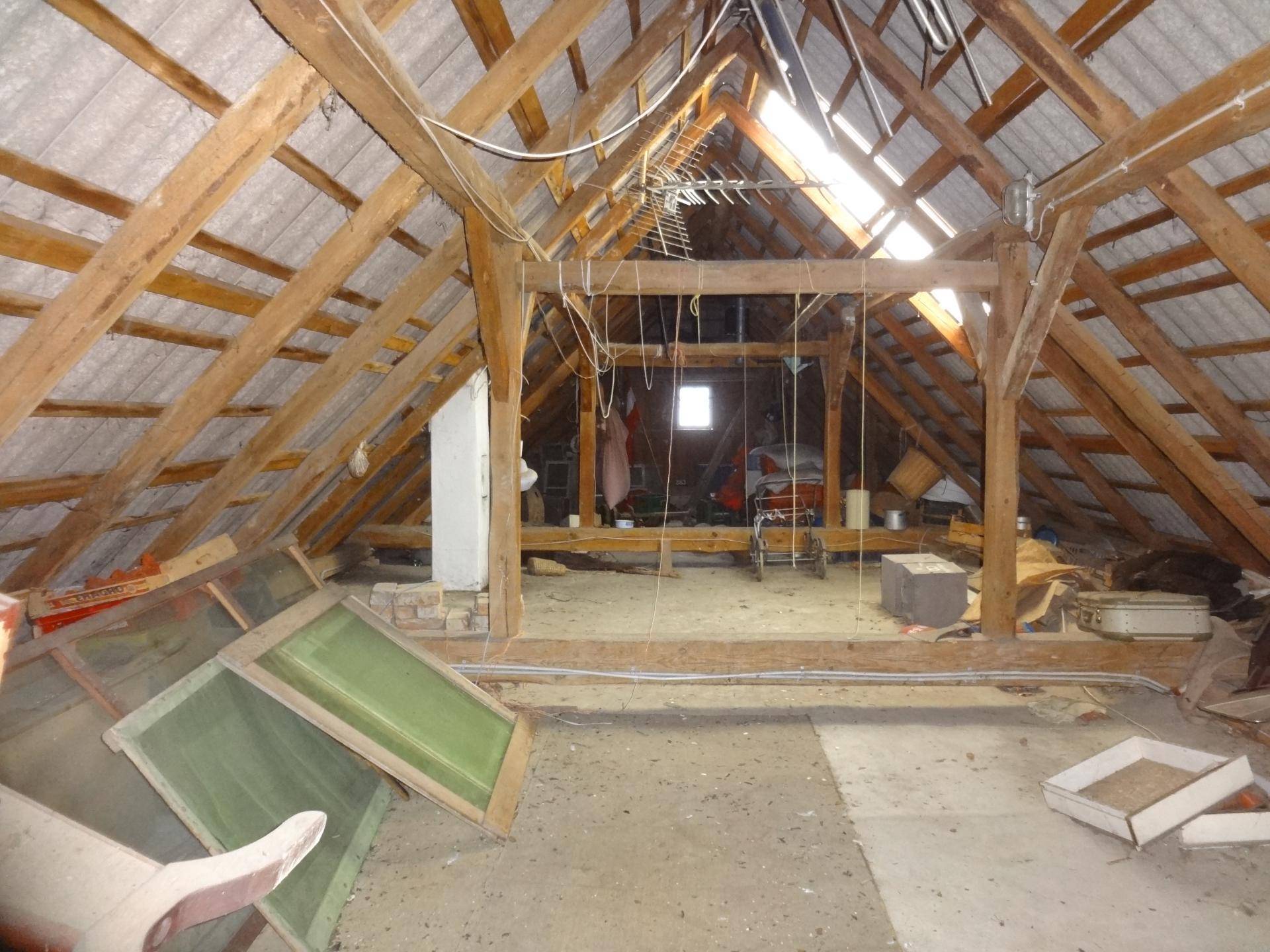 Unausgebauter Dachboden mit sichtbaren Holzbalken und viel Stauraum.