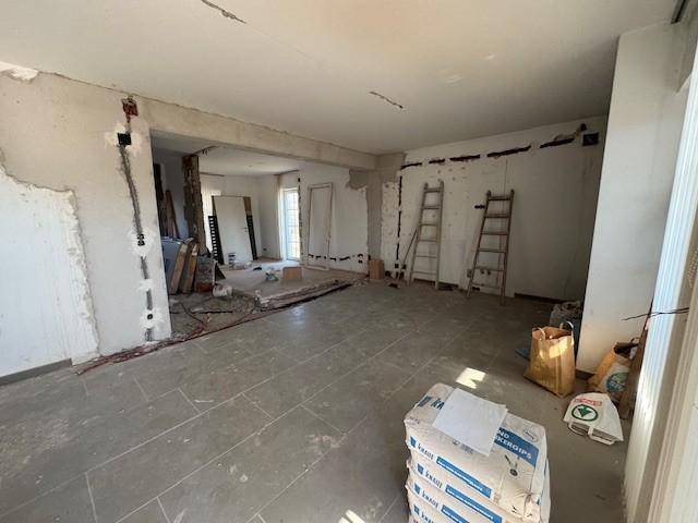 Geräumiger Wohnbereich im Rohbau mit sichtbaren Installationen und viel Potenzial.