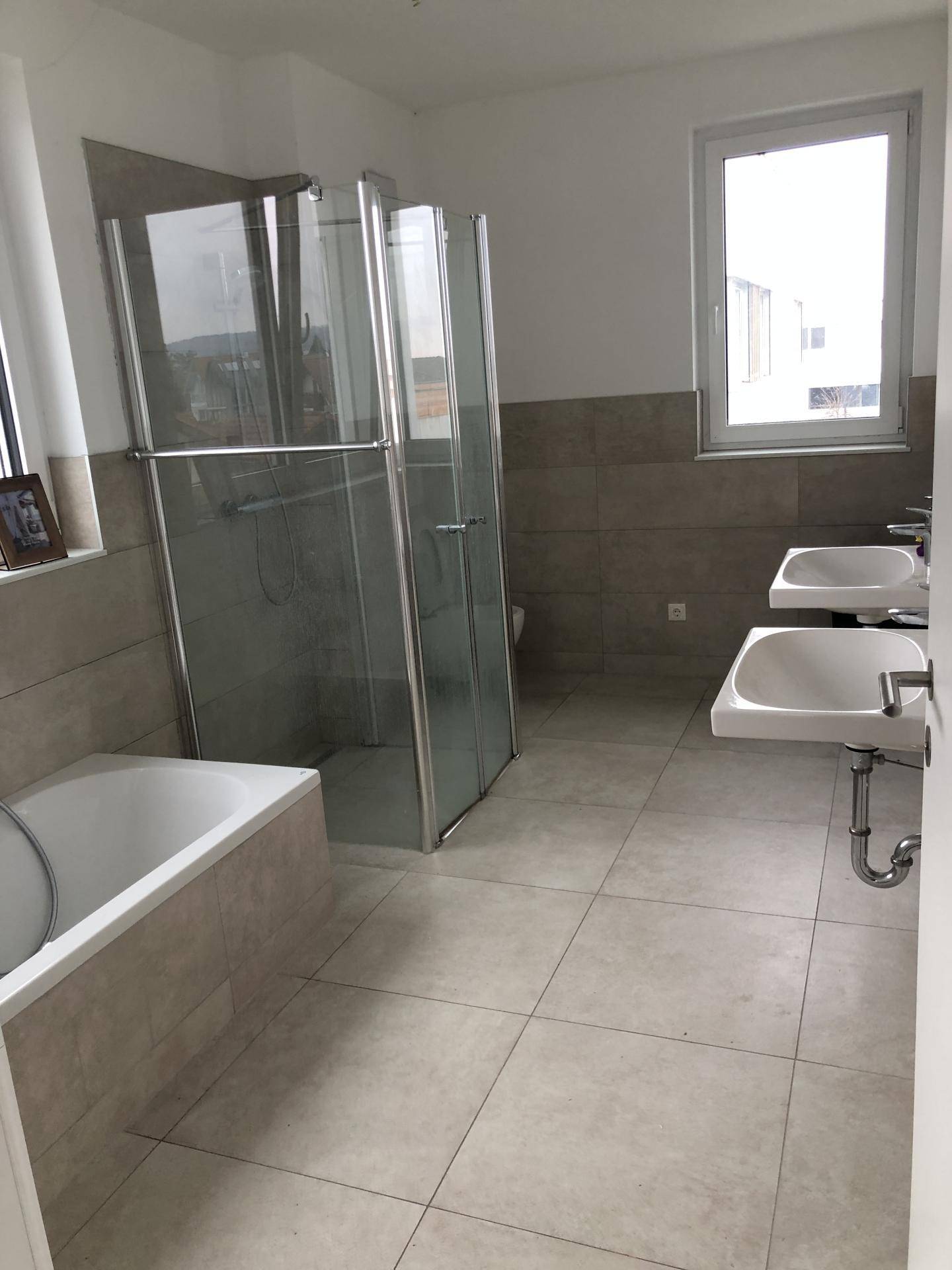 Geräumiges Badezimmer mit Doppelwaschbecken, Badewanne und Duschkabine.