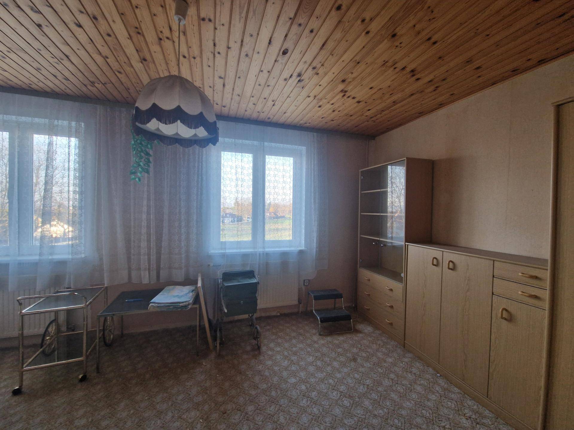 Geräumiges Zimmer im Dachgeschoss mit Holzdecke und Blick ins Grüne, gemütlich eingerichtet.