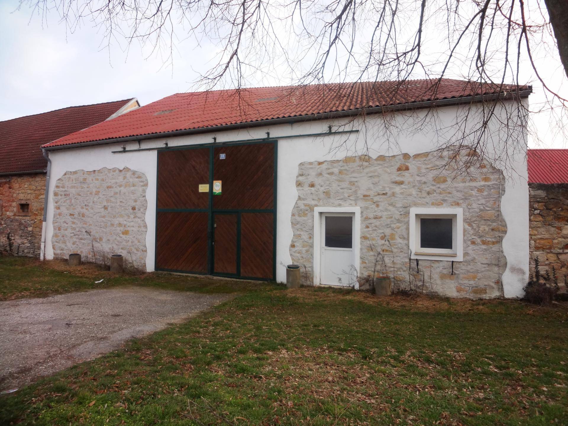 Rustikales Scheunengebäude mit Steinfassade und großen Holztoren.