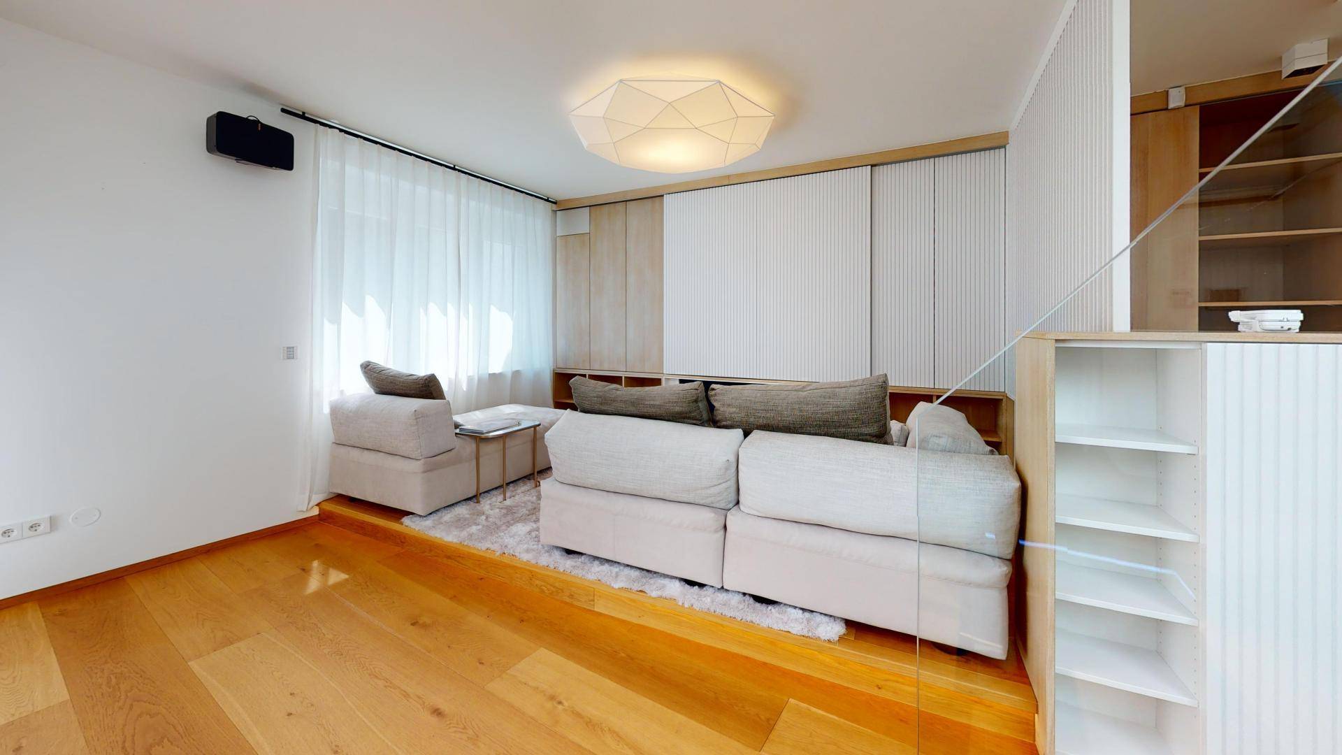 Gemütliches Wohnzimmer mit hellem Sofa, Holzparkett und integrierten Regalelementen für Stauraum.