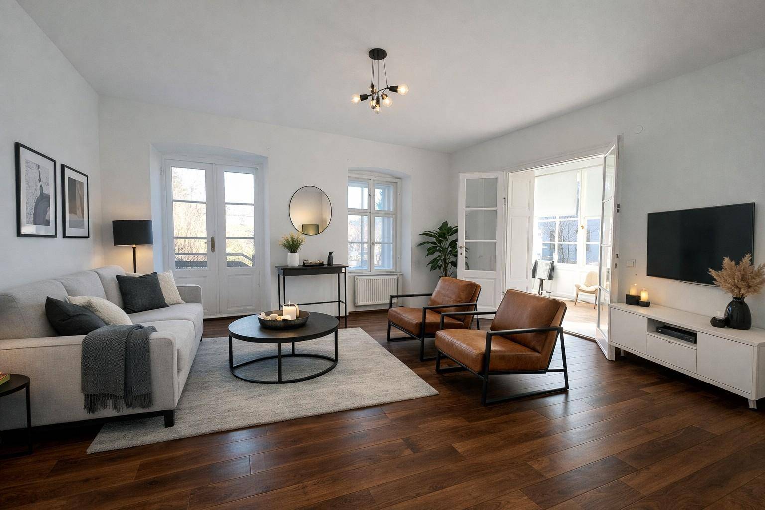 Modern eingerichtetes Wohnzimmer mit Holzboden, bequemen Sofas und viel Tageslicht.