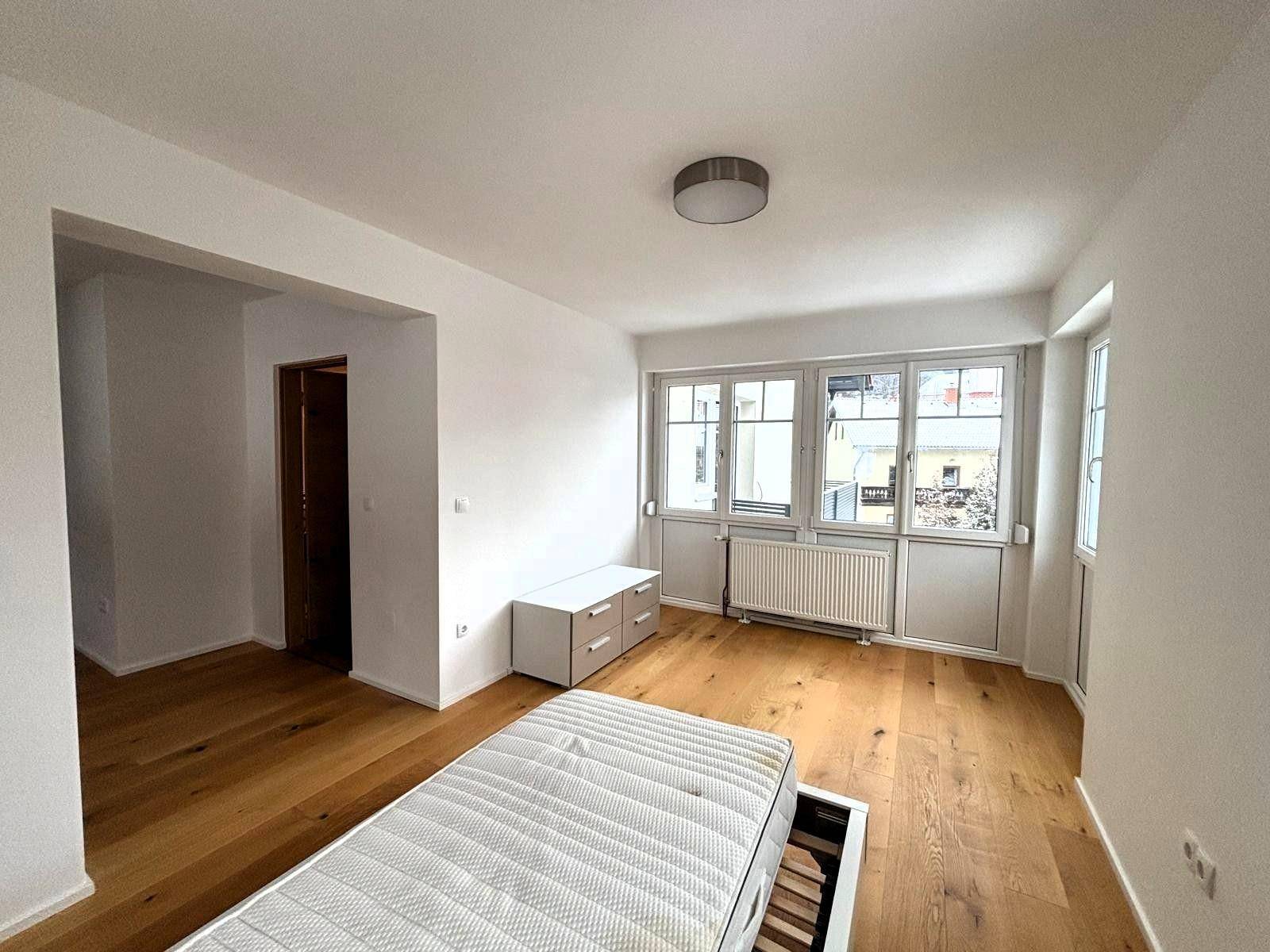 Helles Schlafzimmer mit Holzboden, großem Fenster und viel Platz für individuelle Gestaltung.