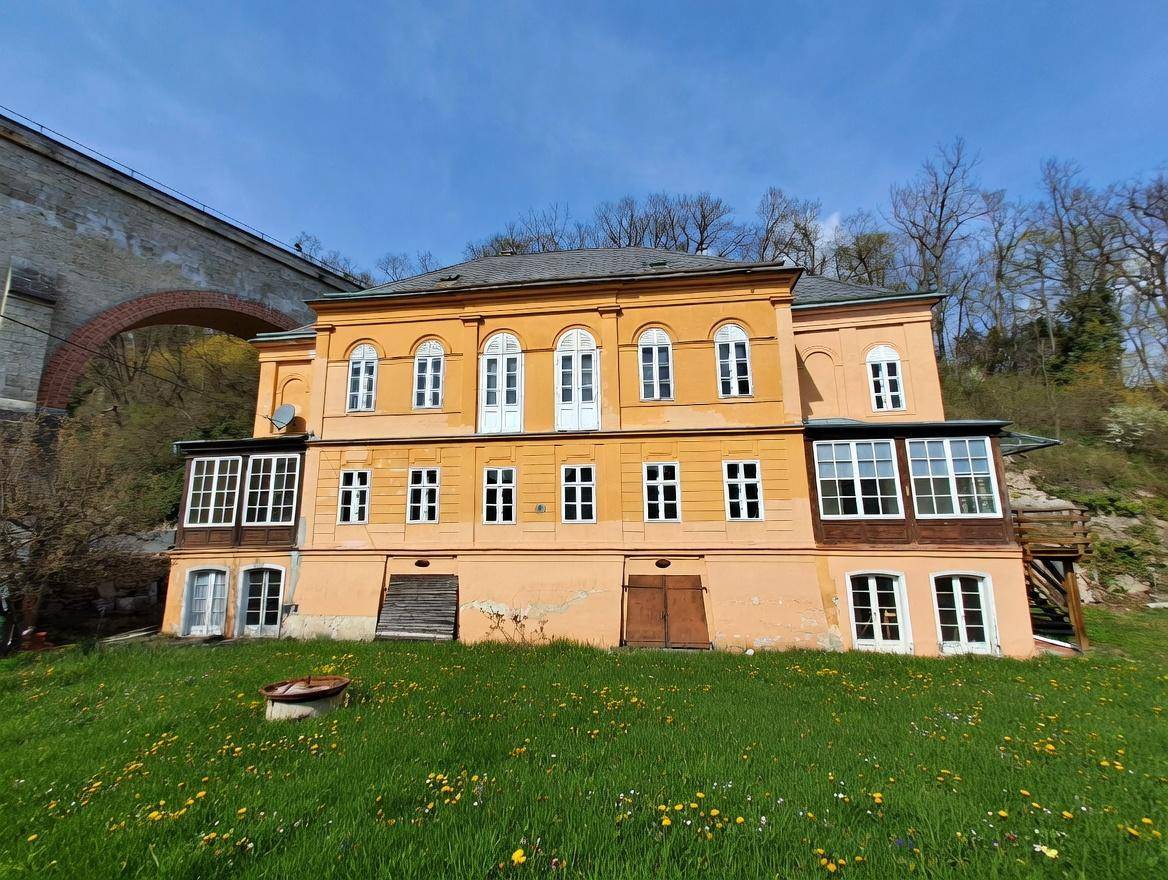 Gesamtansicht des historischen Gebäudes von der Gartenseite mit Wintergarten und Balkon.