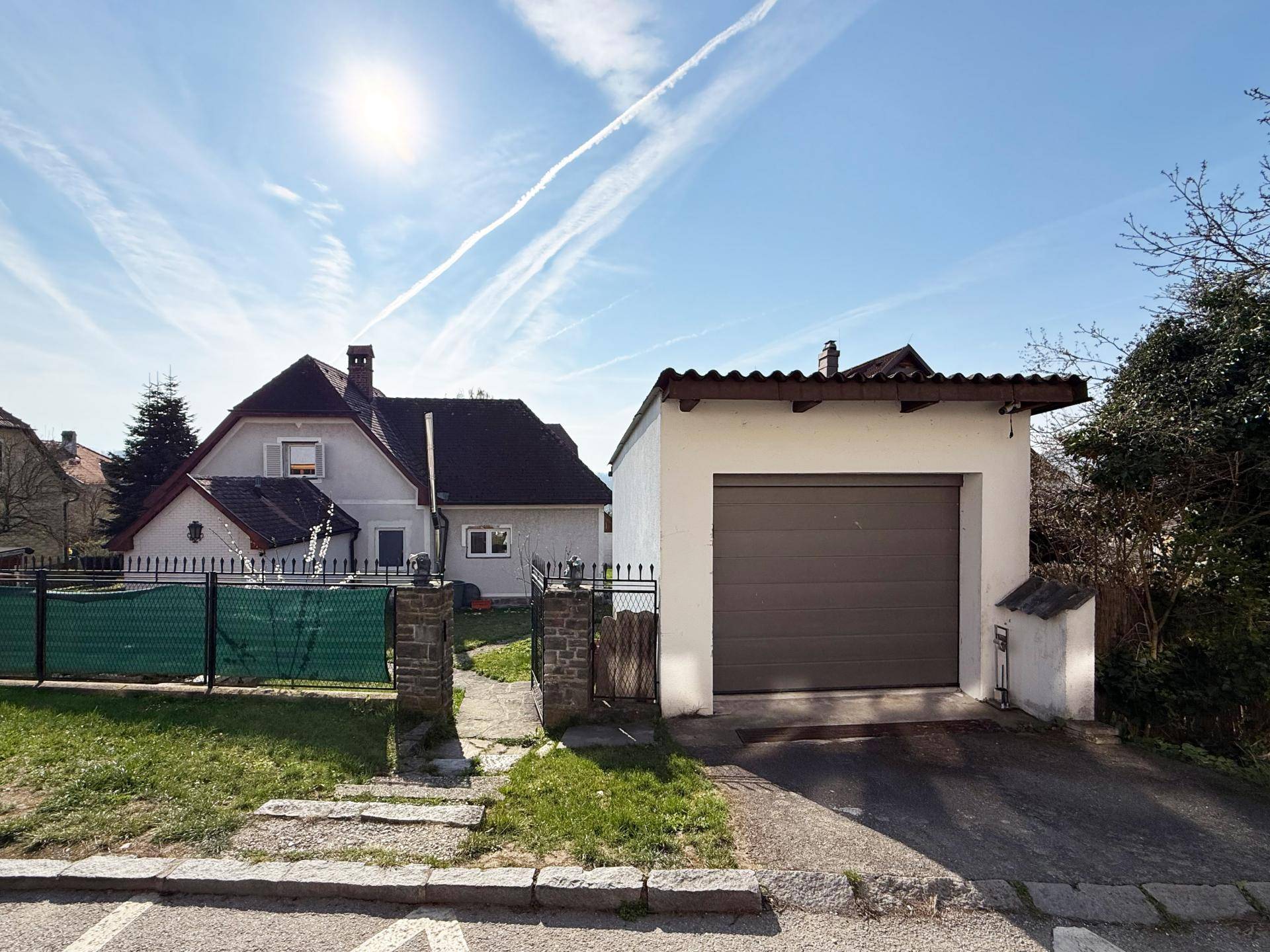 Freistehende Garage mit Rolltor und Zufahrt, neben dem Haupthaus gelegen.