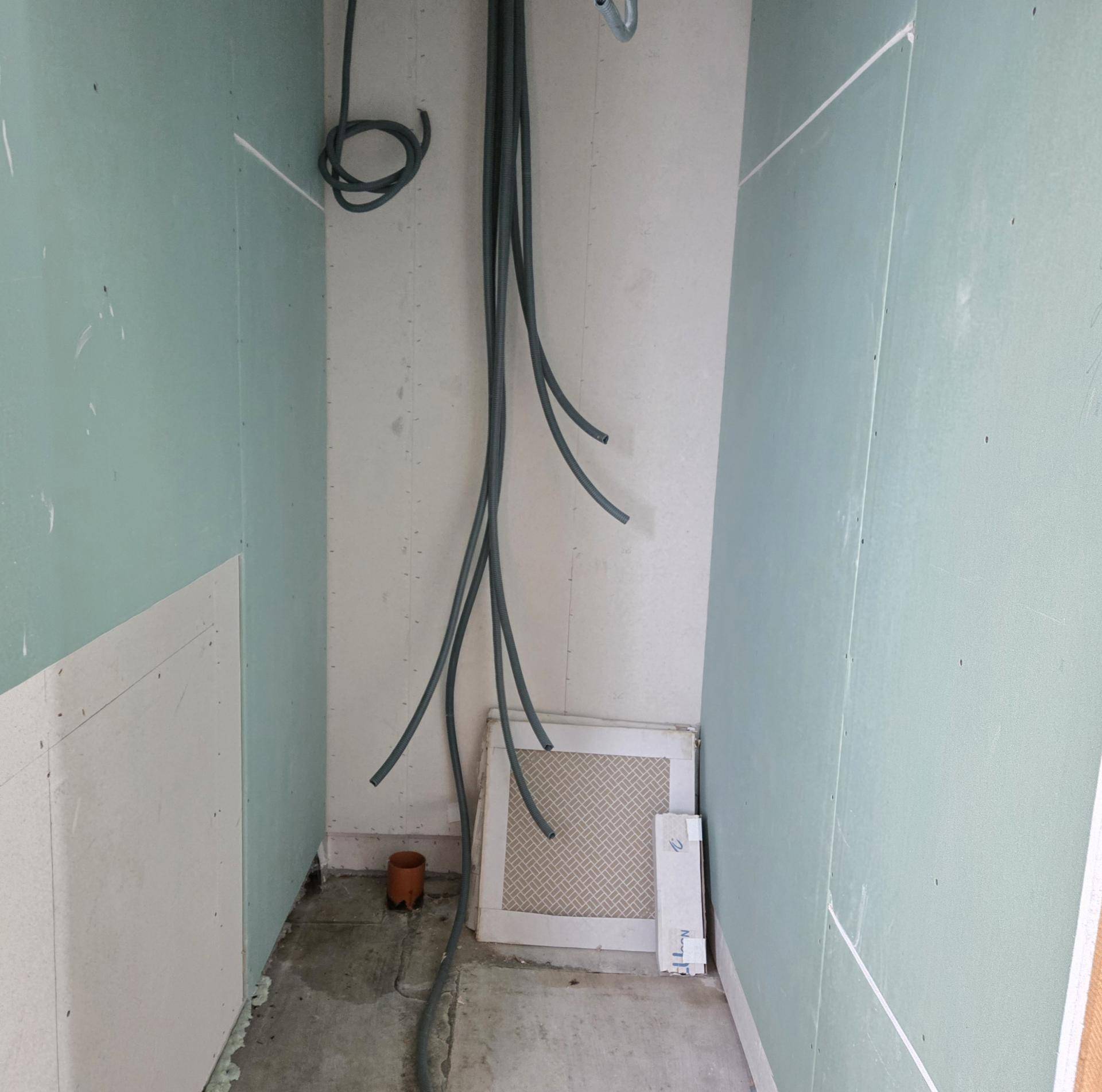 Unfertiger Raum mit sichtbaren Elektroinstallationen und Trockenbauwänden, bereit für den Ausbau.