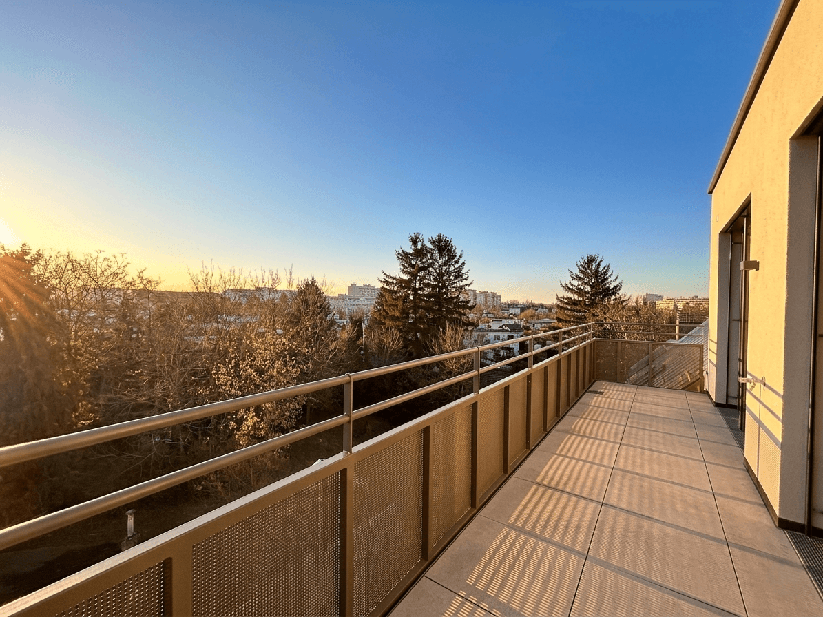 Langer Balkon mit Metallgeländer und Panoramablick auf die Stadt und die Natur.