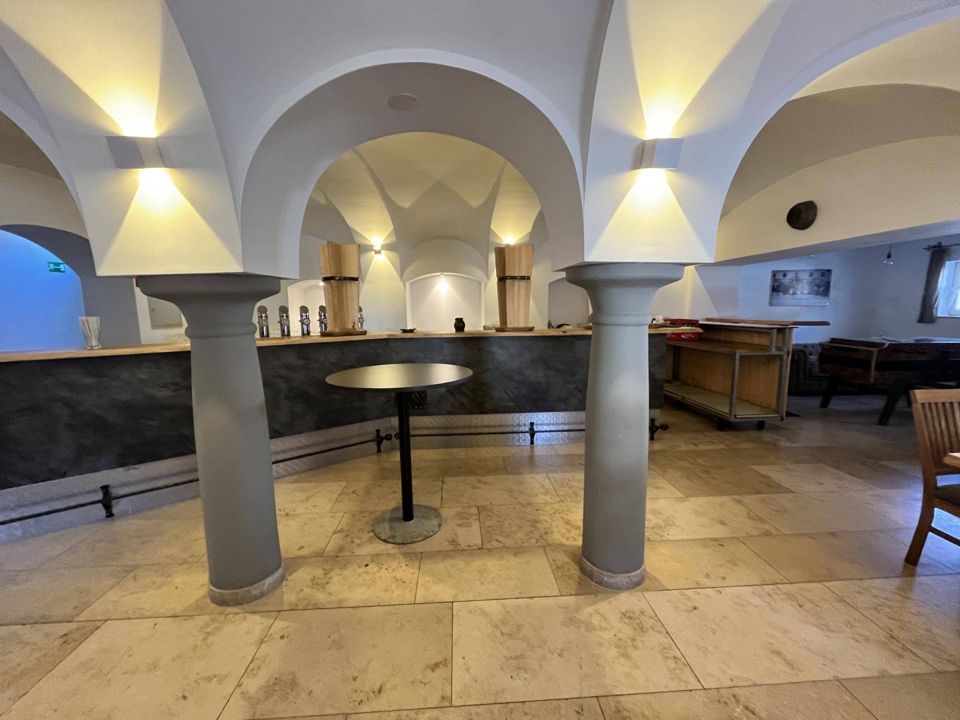 Gewölbekeller mit Säulen, Steinboden und einer Bar, ideal für Veranstaltungen.