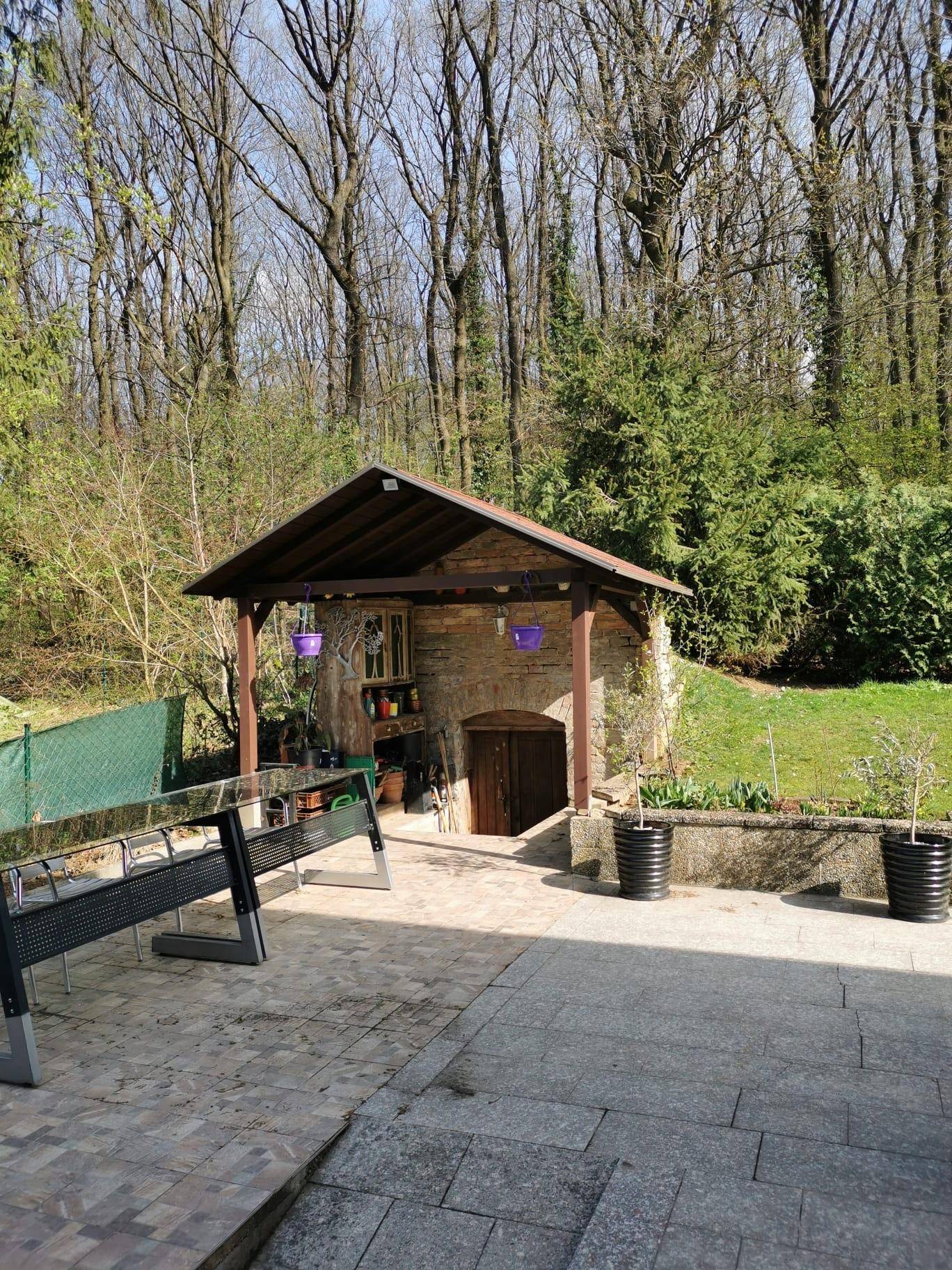 Gemütliche Terrasse mit Sitzgelegenheiten und einem rustikalen Kellerzugang im Hintergrund.