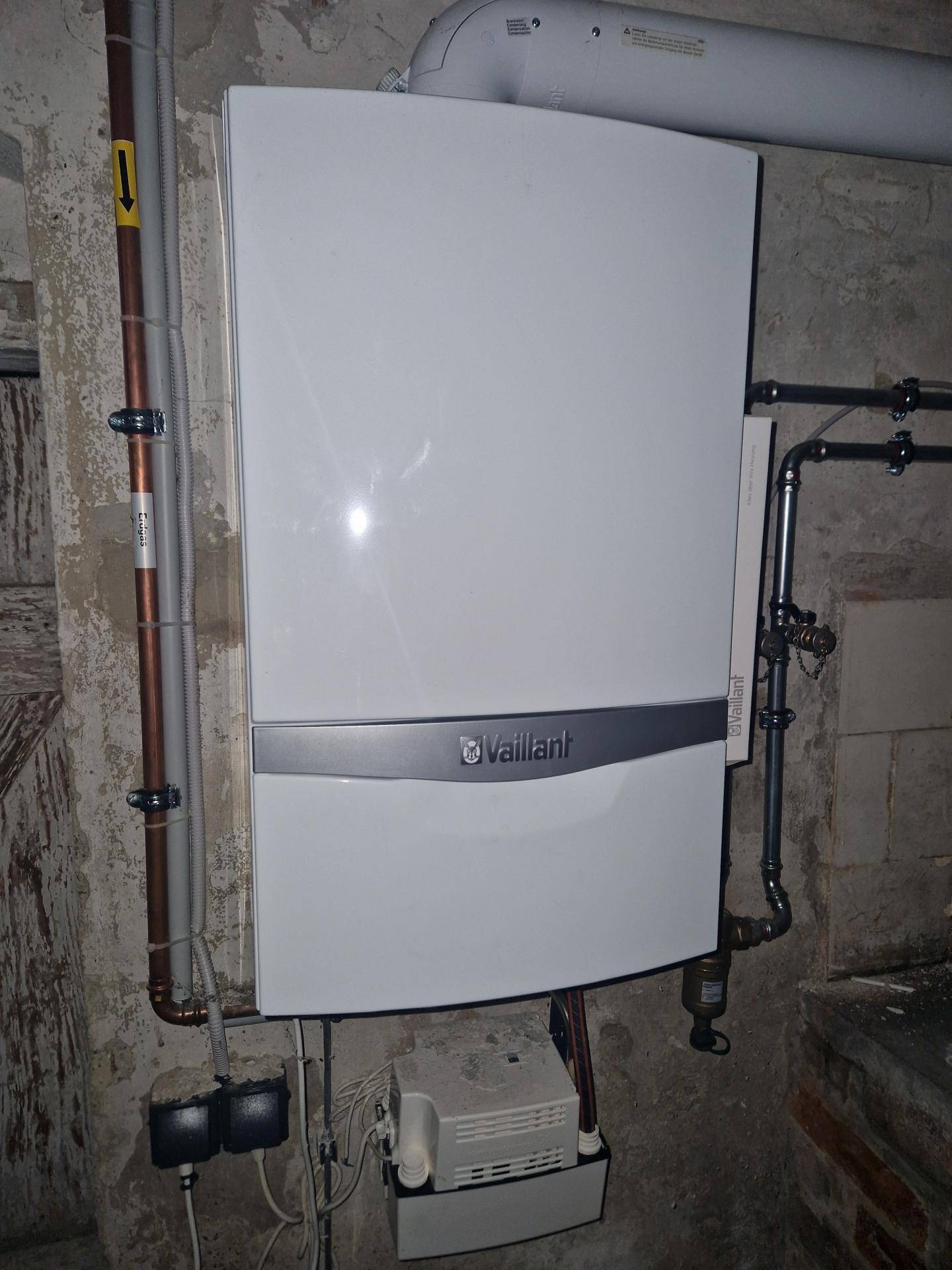 Heizungsraum mit einer modernen Vaillant Gastherme und sichtbaren Rohrleitungen.