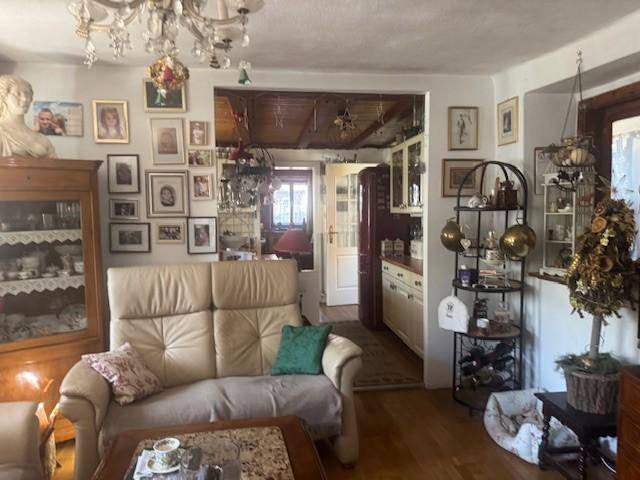 Gemütliches Wohnzimmer mit beiger Couch, Holzboden und vielen persönlichen Dekorationen.