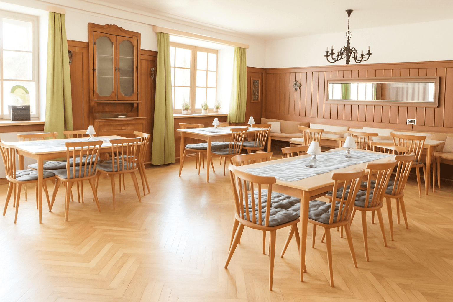 Geräumiger Speisesaal mit Holzvertäfelung, Parkettboden und vielen Tischen.