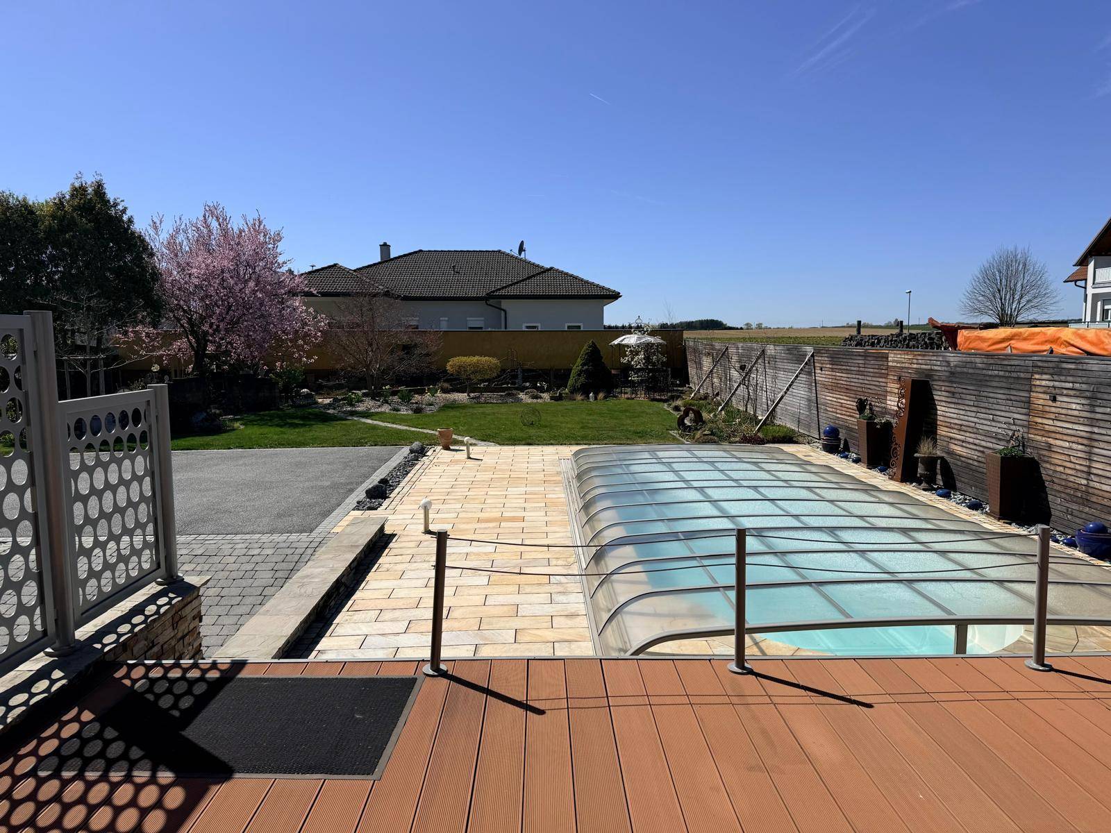 Terrasse mit Pool und Blick auf den Garten und die umliegende Landschaft.