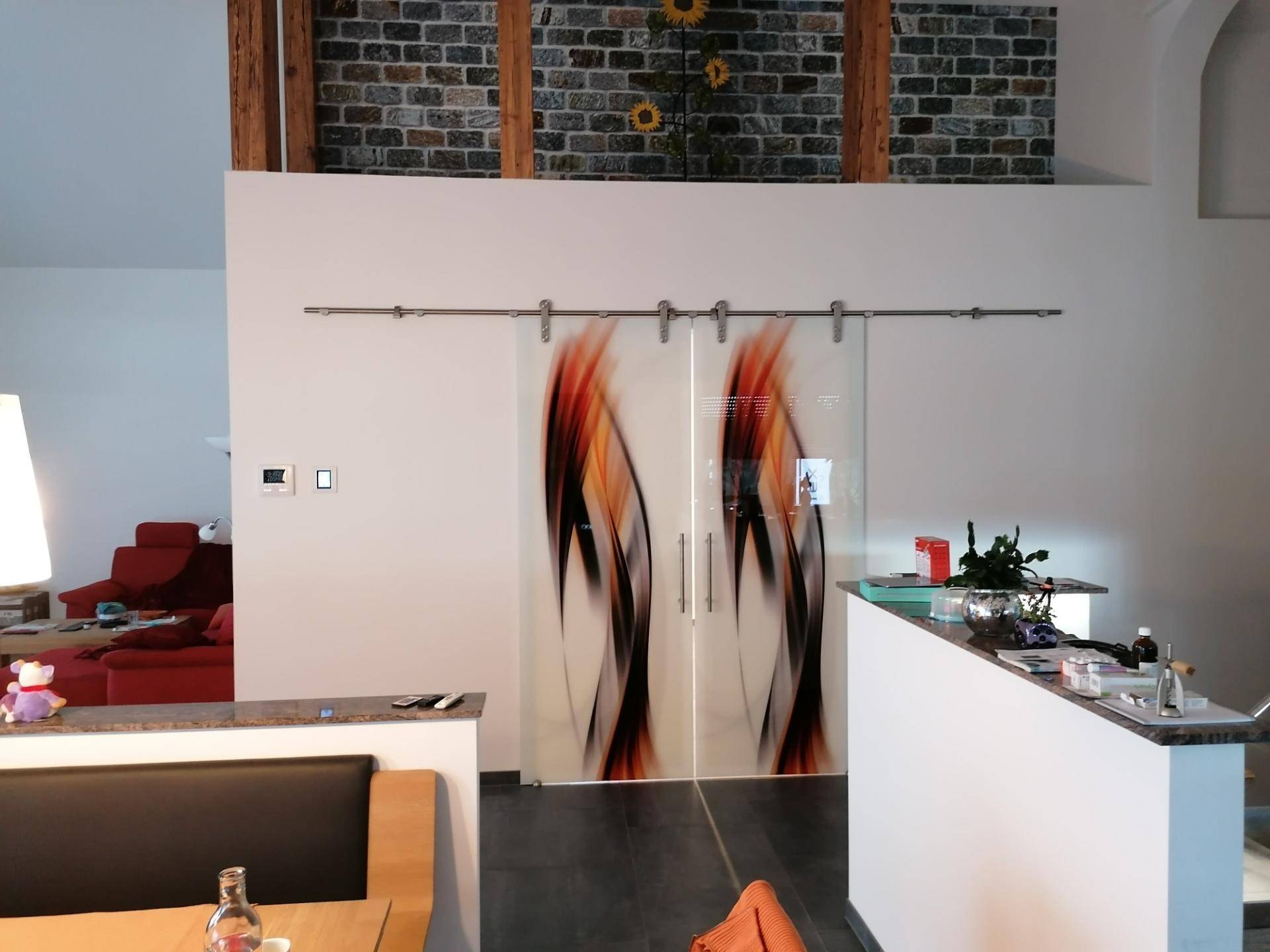 Wohnbereich mit dekorativen Glasschiebetüren, Holzbalken und moderner Einrichtung, offen und hell.