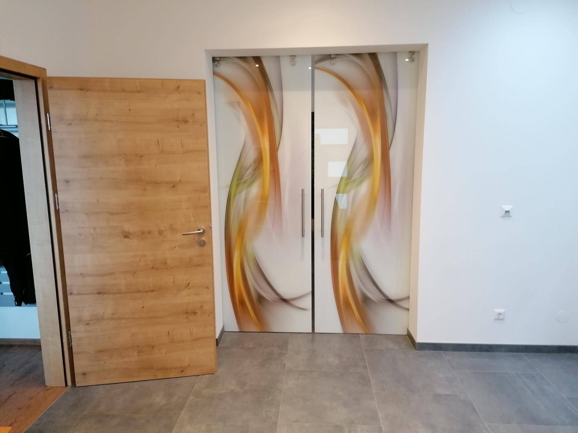 Heller Flur mit modernen Schiebetüren aus Glas und Fliesenboden, elegant und einladend gestaltet.